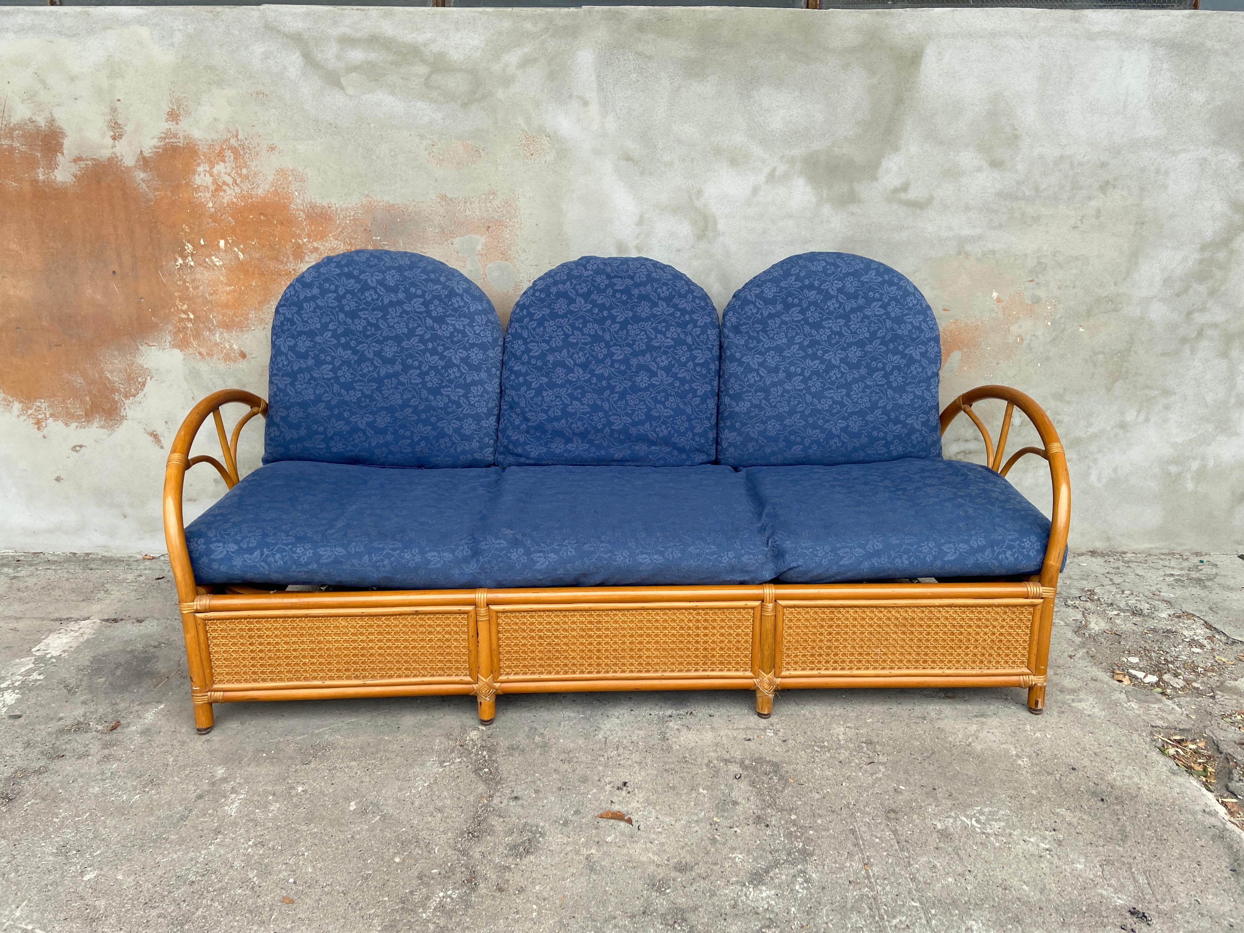 Mid-Century Modern Italian bamboo and rattan sofa with original blue fabric cushions.
The basement of the sofa has a beautiful decoration made with framed 