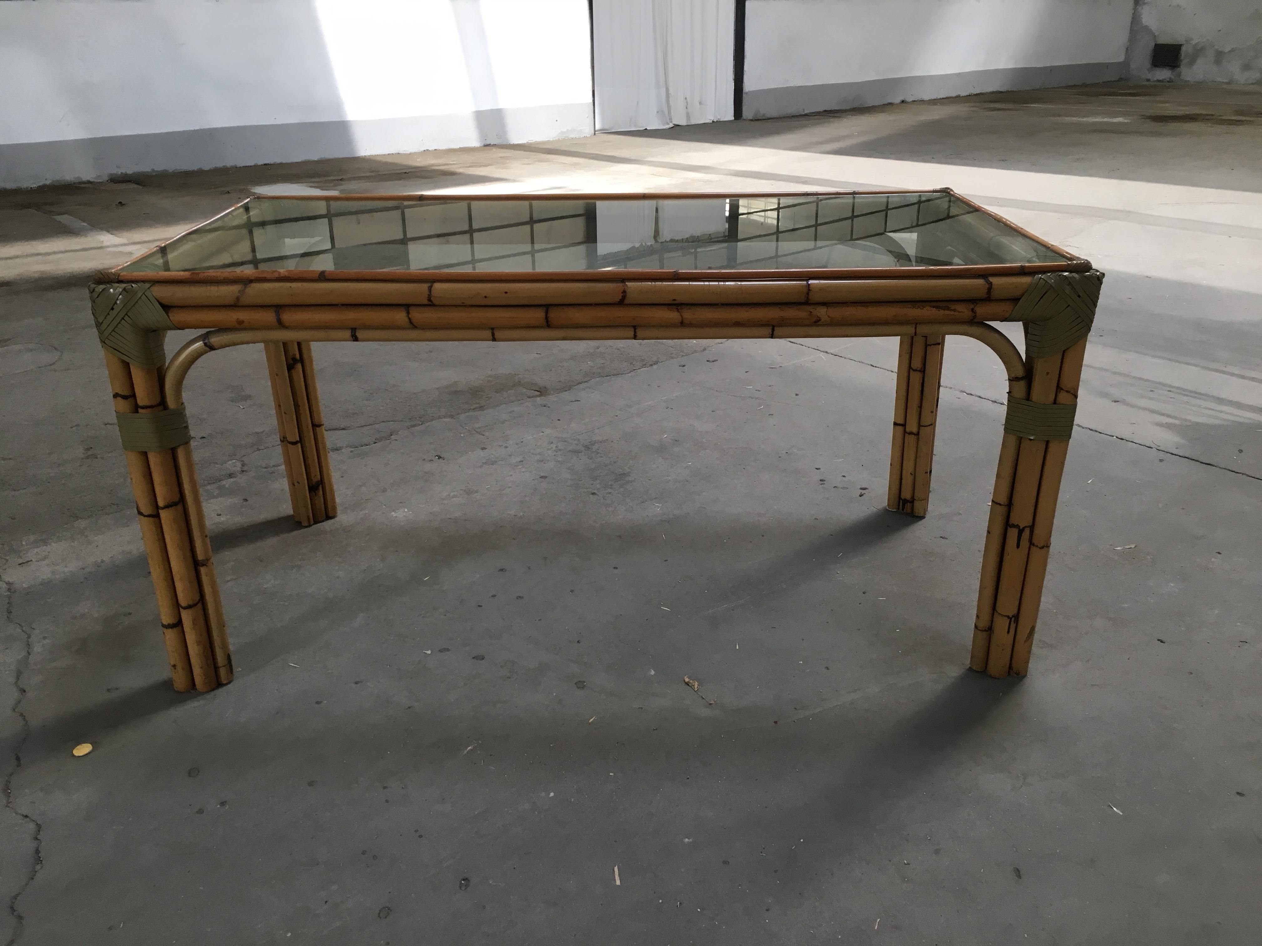 Mid-Century Modern bamboo and glass Italian dining table. All the binding are made with leather laces.
The table could be sold as a set with four chairs as shown in the picture. 
Price on demand.