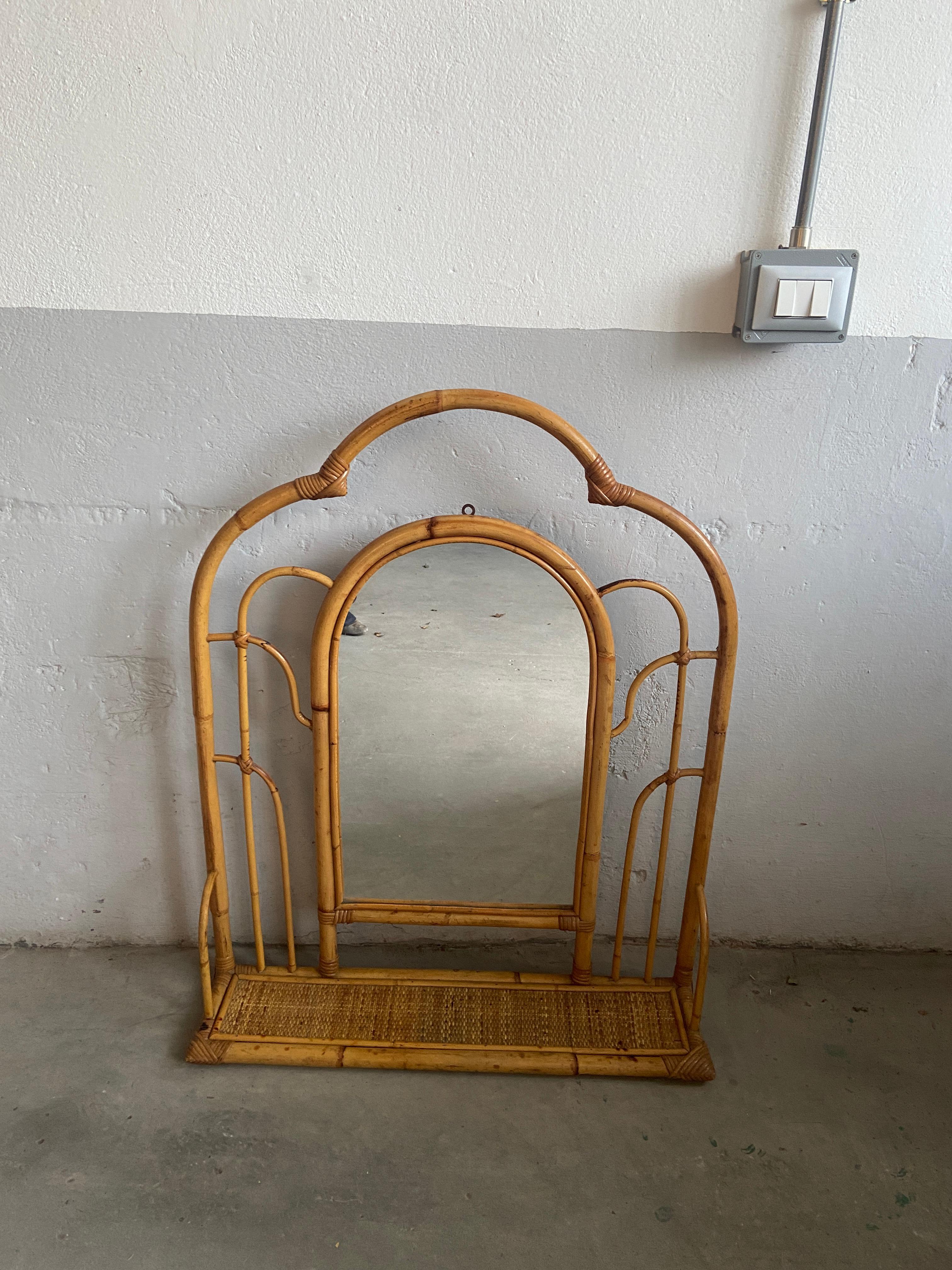 Mid-Century Modern Italian bamboo framed wall mirror with rattan shelf.
The mirror is in really perfect vintage conditions.