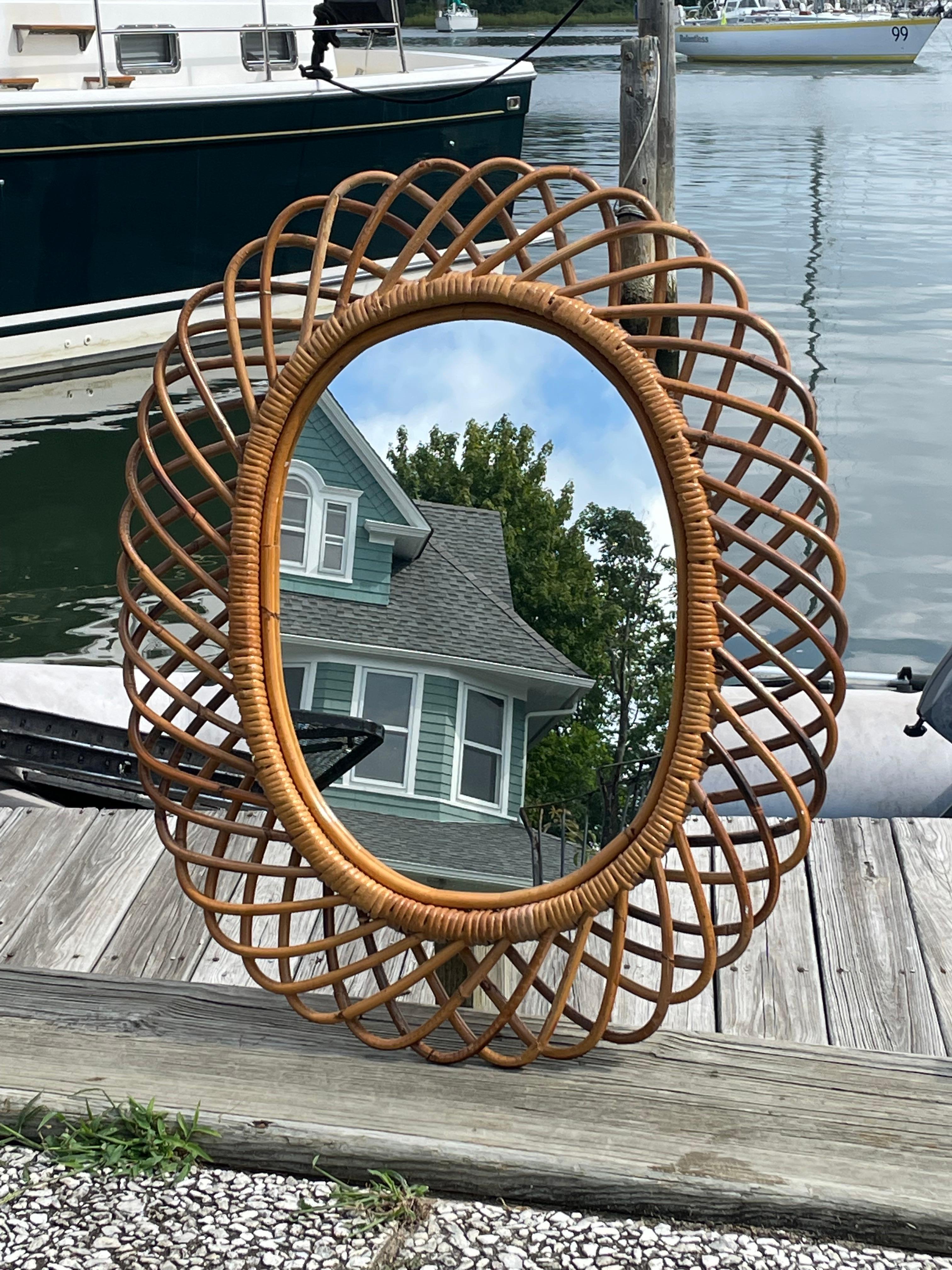 Beautiful bamboo and rattan oval Sunburst mirror . This Italian designed Franco Albini style features looping bamboo held into rattan bands around the large mirror . These handcrafted mirrors were typical in Italy in the 1950s-1970s. This one has