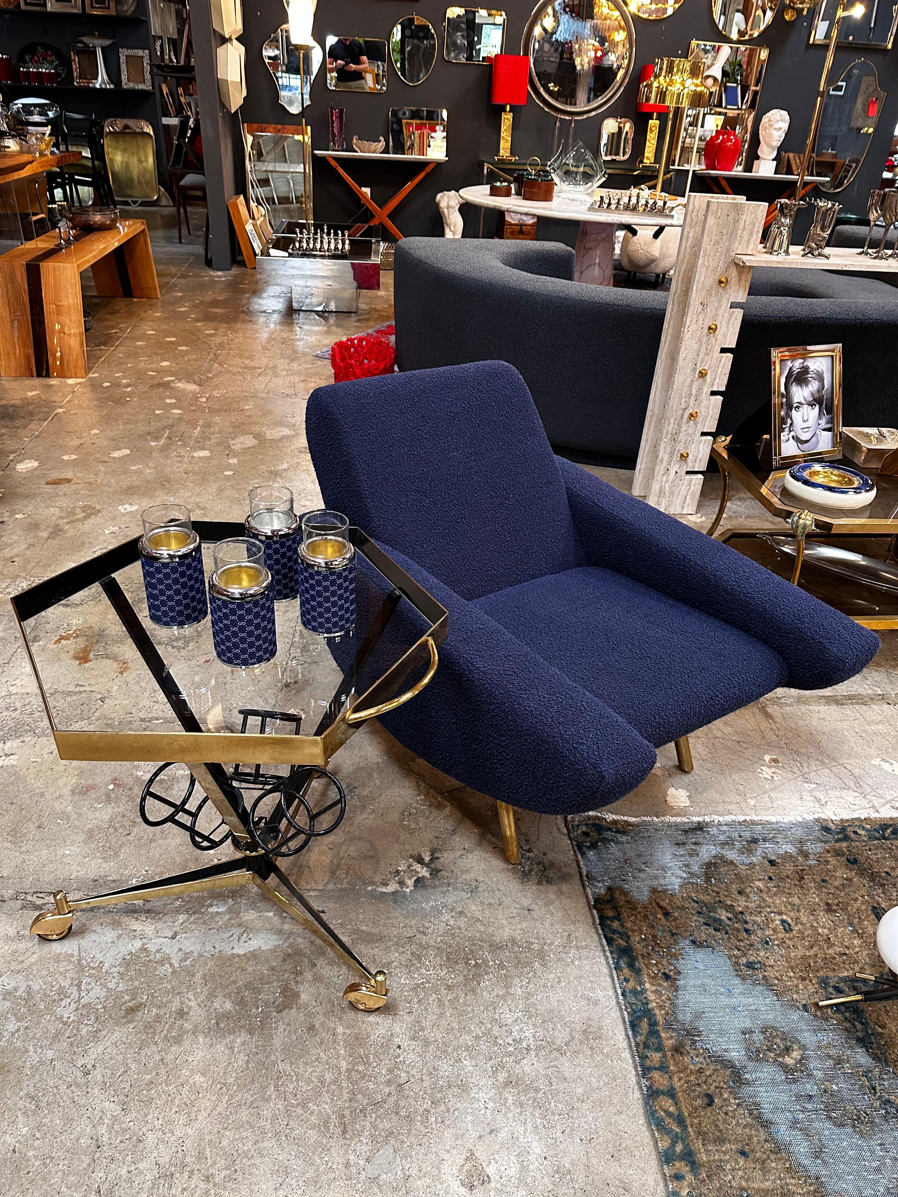 The Mid Century Modern Italian Bar Cart from the 1960s, featuring brass tires and a metal frame with a 3-bottle holder, is a stylish and functional piece of vintage furniture. Its design perfectly encapsulates the mid-century aesthetic with clean