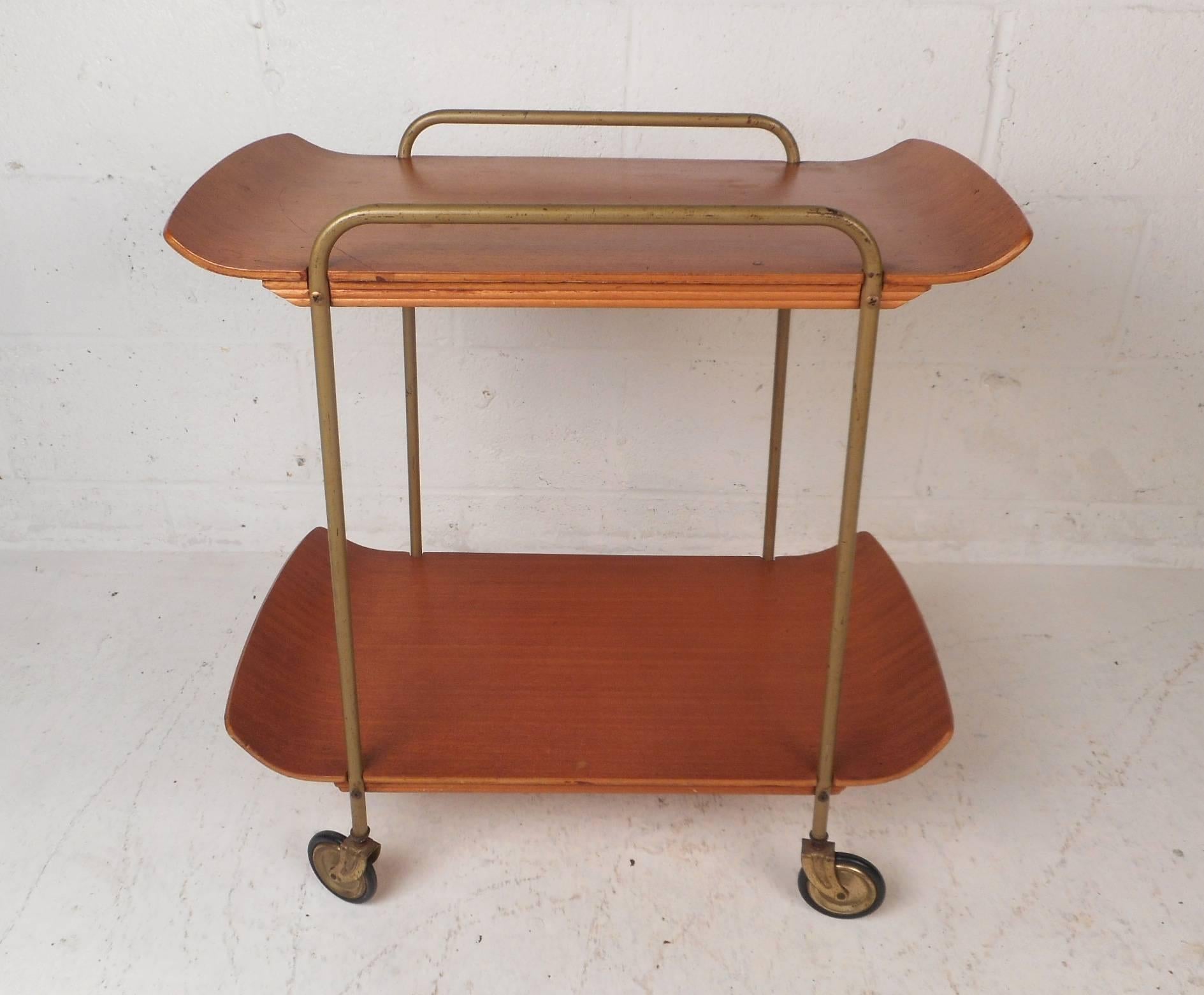 This gorgeous vintage modern bar cart features two bentwood tiers for setting and storing items. Sleek design for four wheels ensuring plenty of convenience without sacrificing style. A stylish metal frame that also functions as a side barrier for