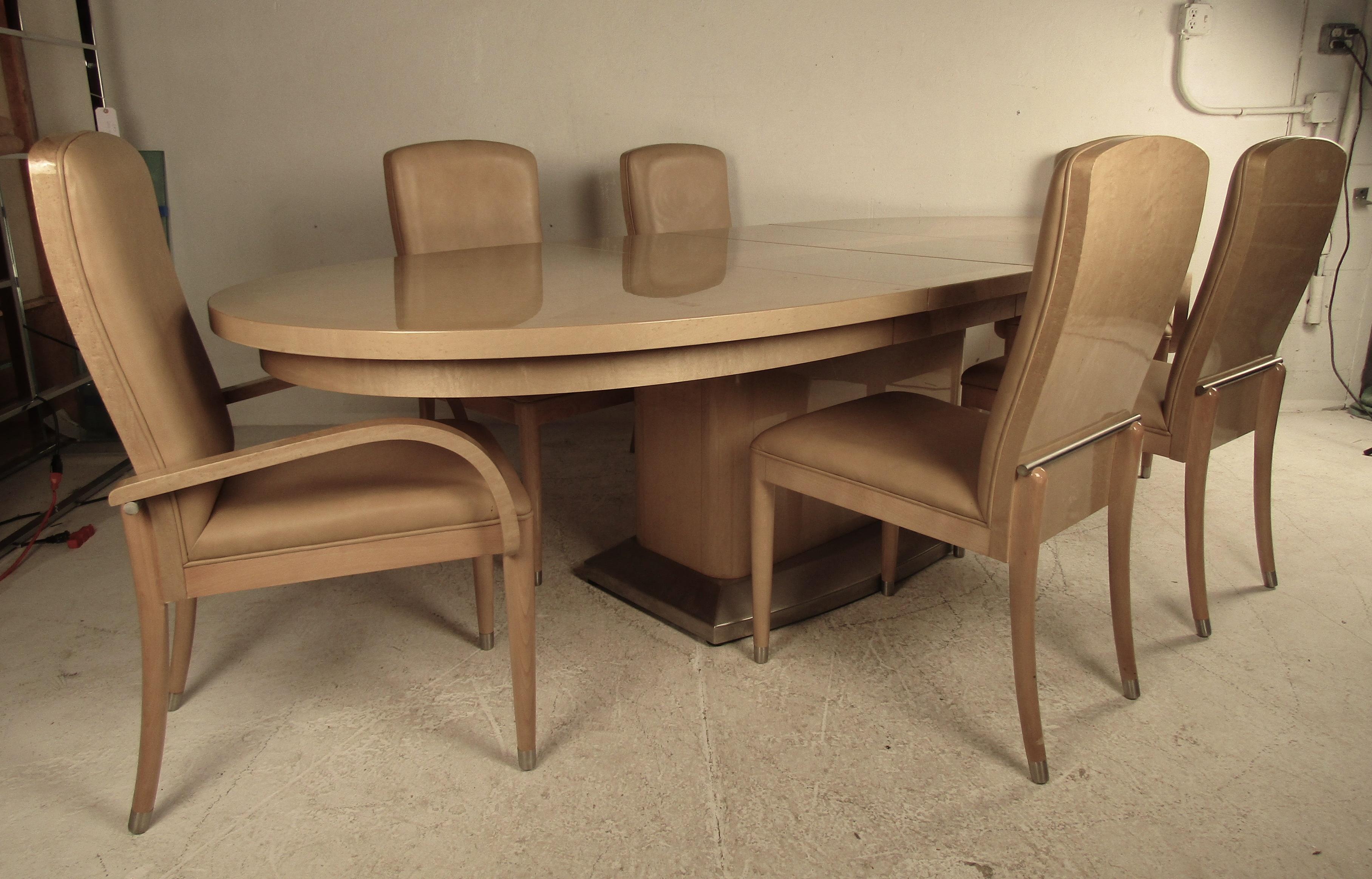 This beautiful vintage modern Italian dining set includes a large oval dining table with two leaves and six chairs. A luxurious dining table that extends from 78.5 inches wide to 113 inches wide. A sleek a comfortable dining set with two armchairs