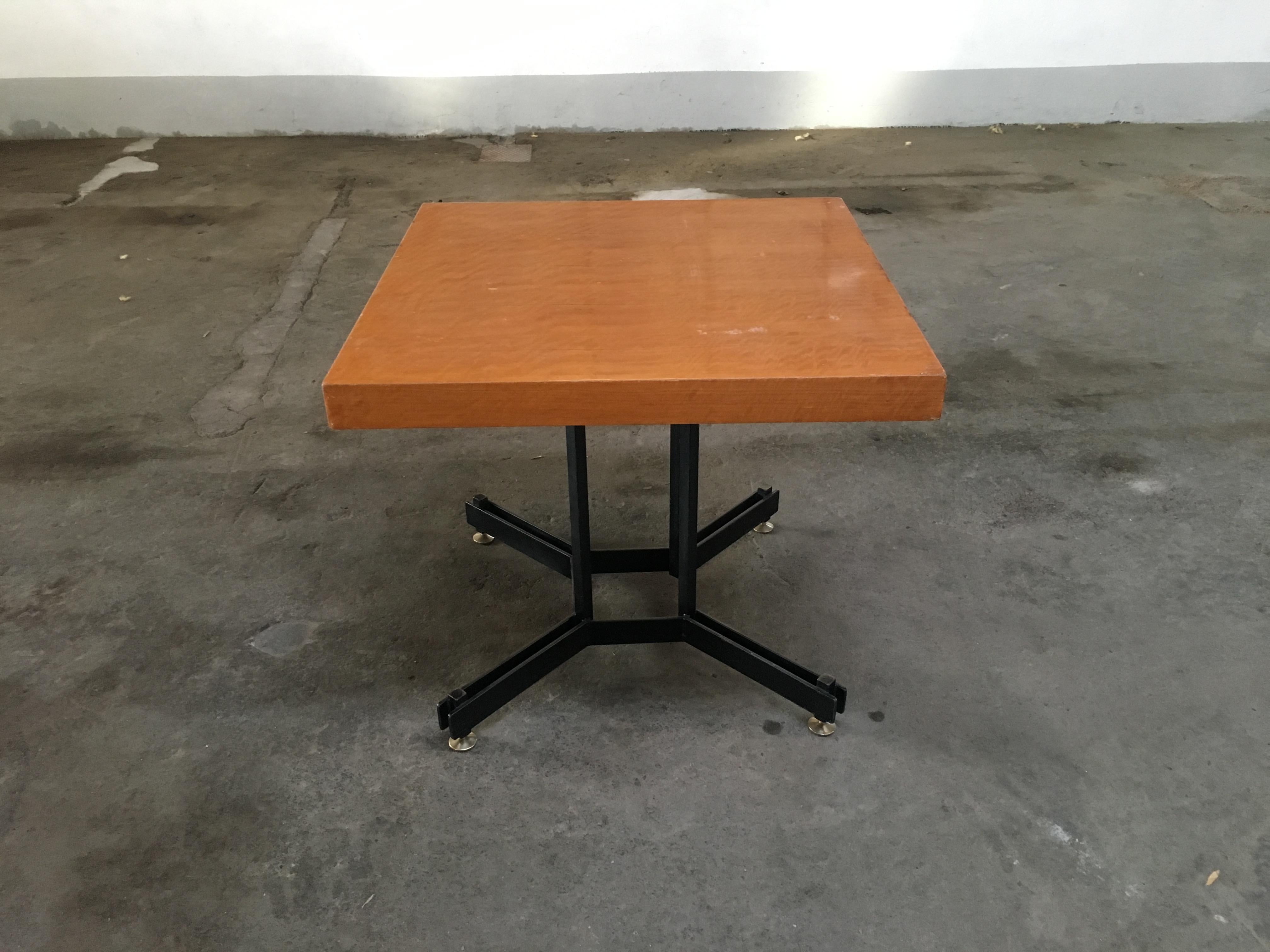 Mid-Century Modern Italian black iron base table with wood top and brass feet. 1970s
The wooden top of the table shows some wear due to age and use.