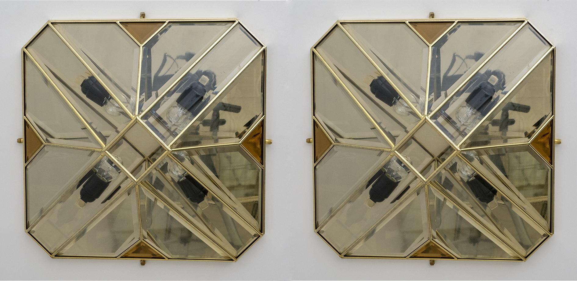 These wall lamps were produced in the 70s in Italy, have a square base and the shape of a parallelepiped, the structure is in brass and the glasses are beveled, this process makes them unique and illuminated have a very particular effect.
They are