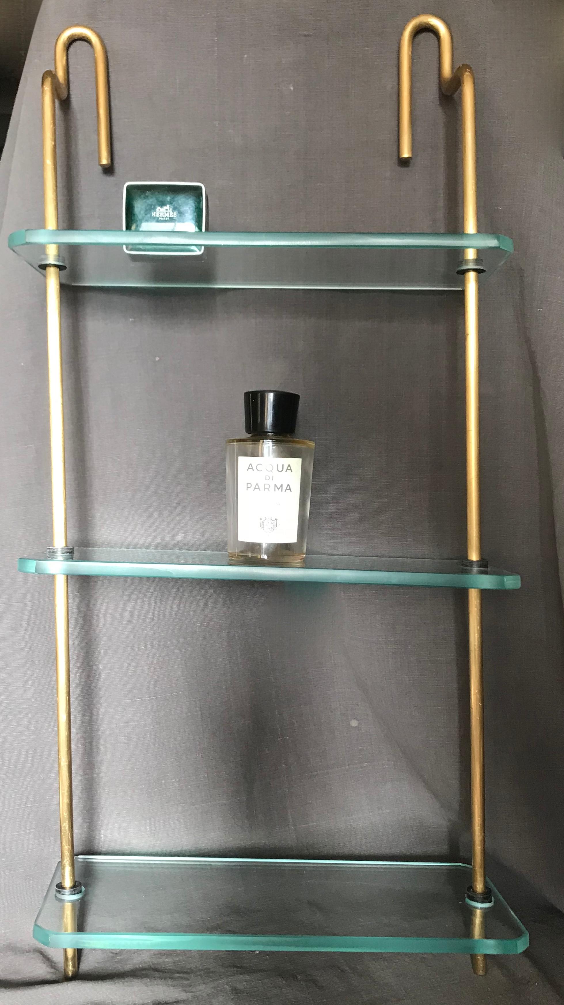 Mid-Century Modern Italian brass and glass hanging shelves. Vintage brass and thick glass shelves perfect for cologne/perfume display etc in bath or dressing room, Italy, 1960s
Italian midcentury brass and glass shelves. Brass and three-tier