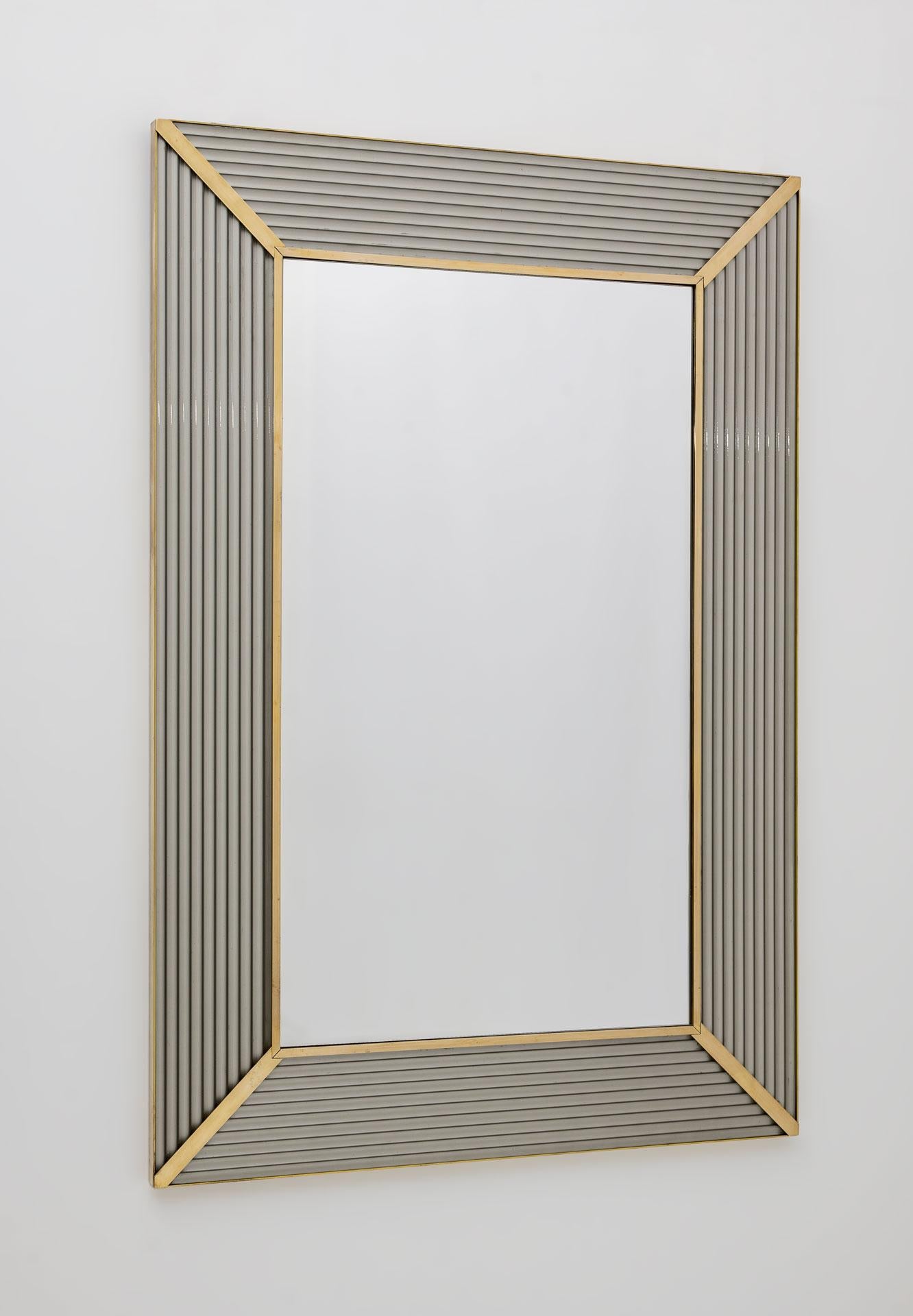 Spiegel mit grauem Murano-Glasrahmen, mit Messingleiste, die Spiegelstruktur ist aus Holz.
Der Spiegel kann sowohl senkrecht als auch waagerecht aufgehängt werden