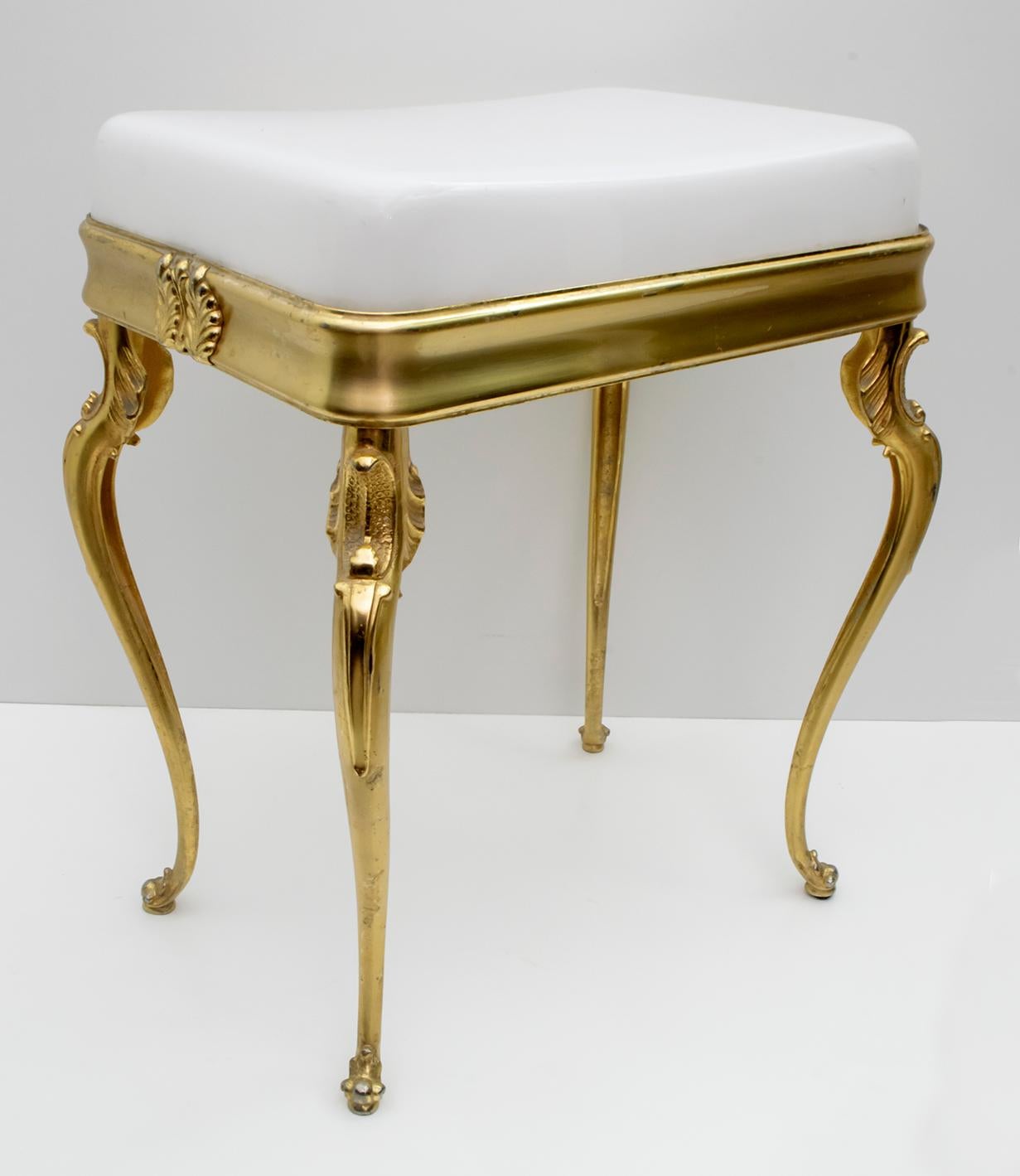 This Italian stool dates back to the 1950s and is made of solid brass and white plexiglass.