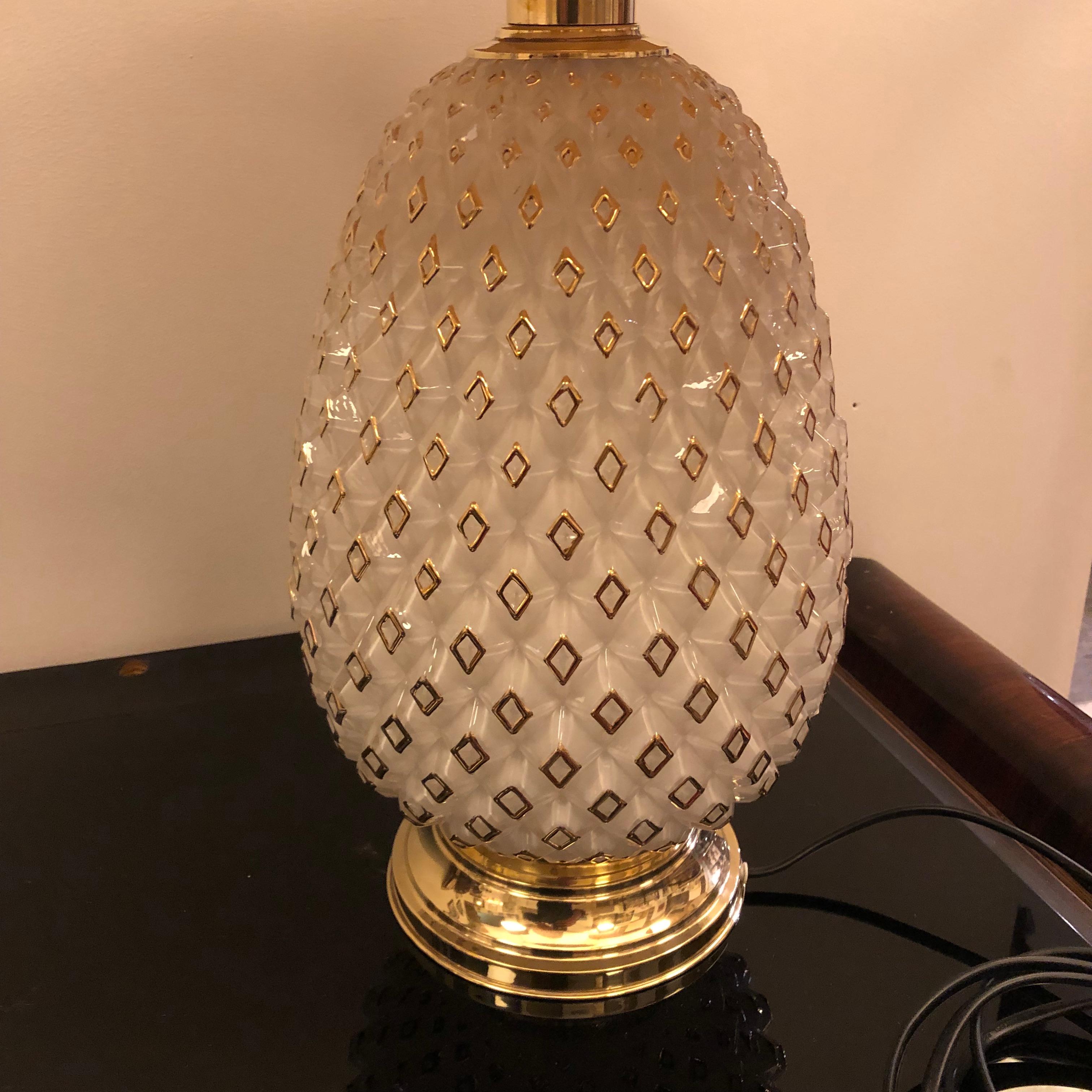Particular pineapple table lamp made in Italy in the Sixties. White opaline glass is decorated with gold finiture, brass has been polished. It works 110-240 volts and need a regular e27 bulb. Sizes without lampshade diameter cm 17, height cm 48.