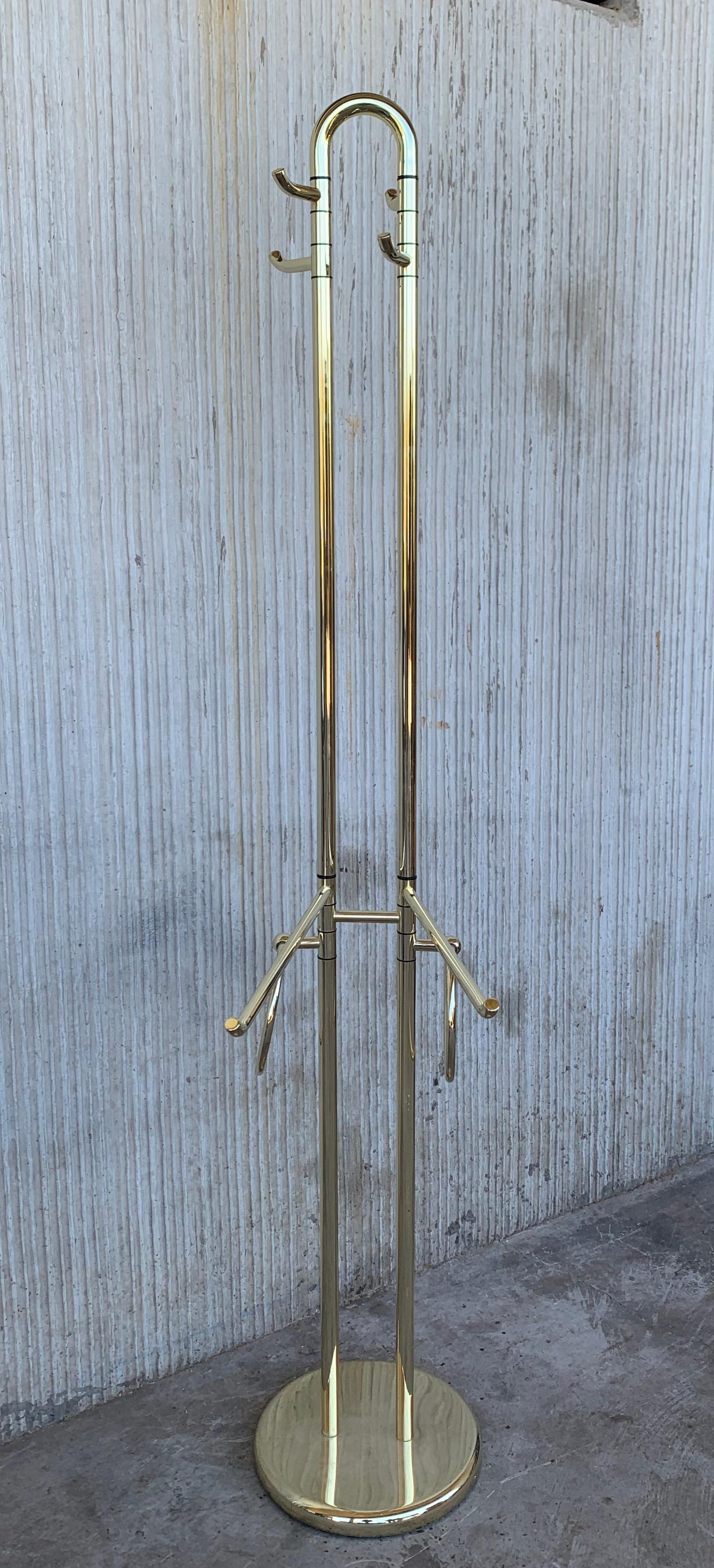 Mid-Century Modern Italian brass coat stand with round base, Italy, 1970s
This heavy coat rack has four high hangers and other four hangers in the middle of the piece. You can move all the hangers in the position you want for a better use.

The