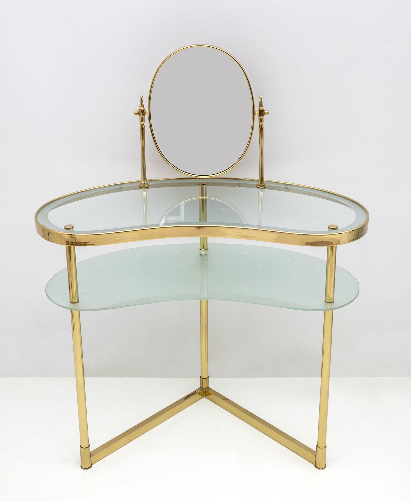Produced in Italy in the 1940s and designed by Luigi Brusotti, wavy-shaped make-up table with brass structure and two decorated and partially etched glass shelves, with lighting.
The brass is in perfect condition as shown in the photos, some small