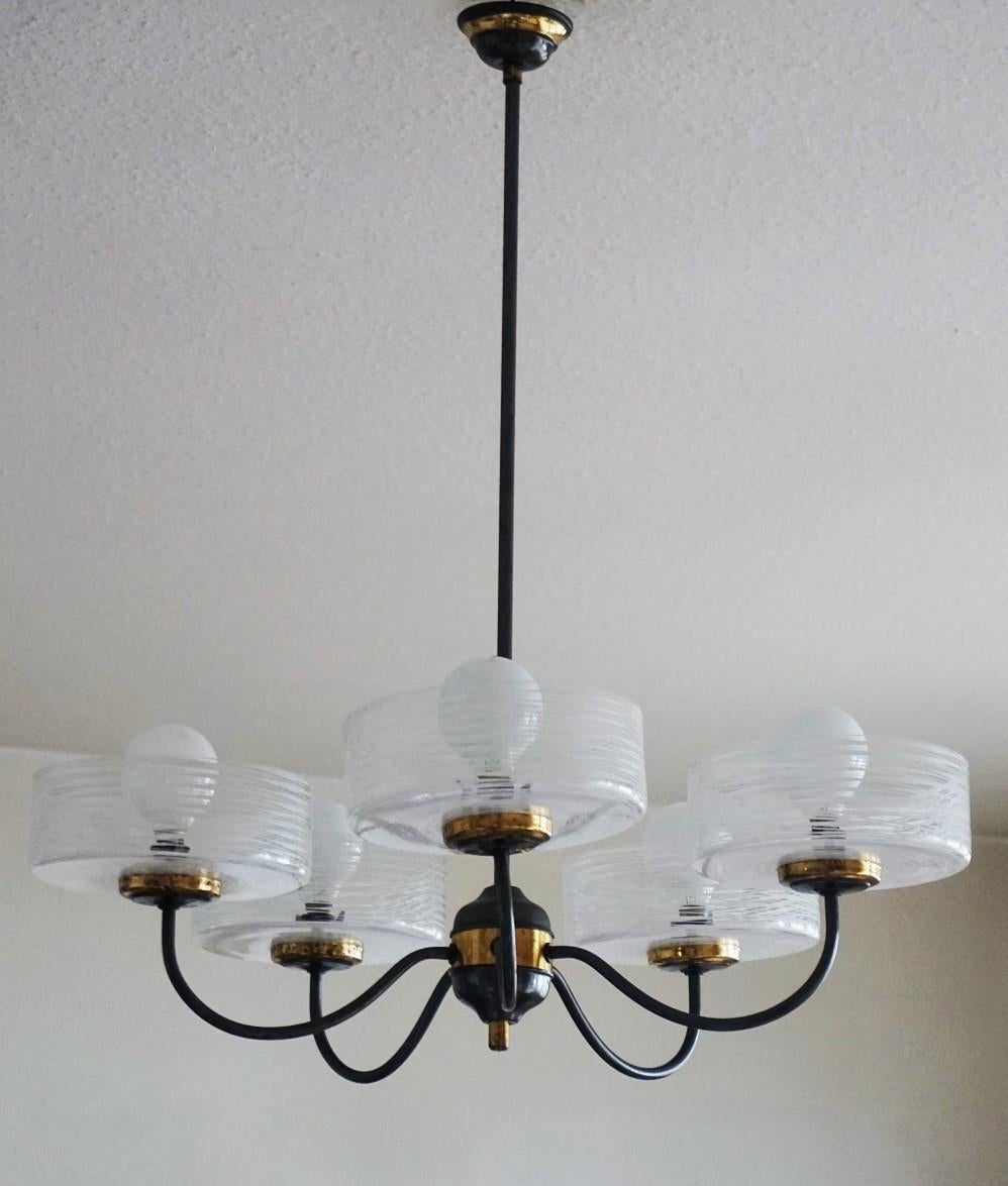 A Stilnovo brass parcel patinated five-light chandelier with large Murano glass shades in modernist clear lines design, Italy, 1950s.
The glass globes are in very good condition, brass with some wear and aged patina, rewired.
Measures:
Height 27