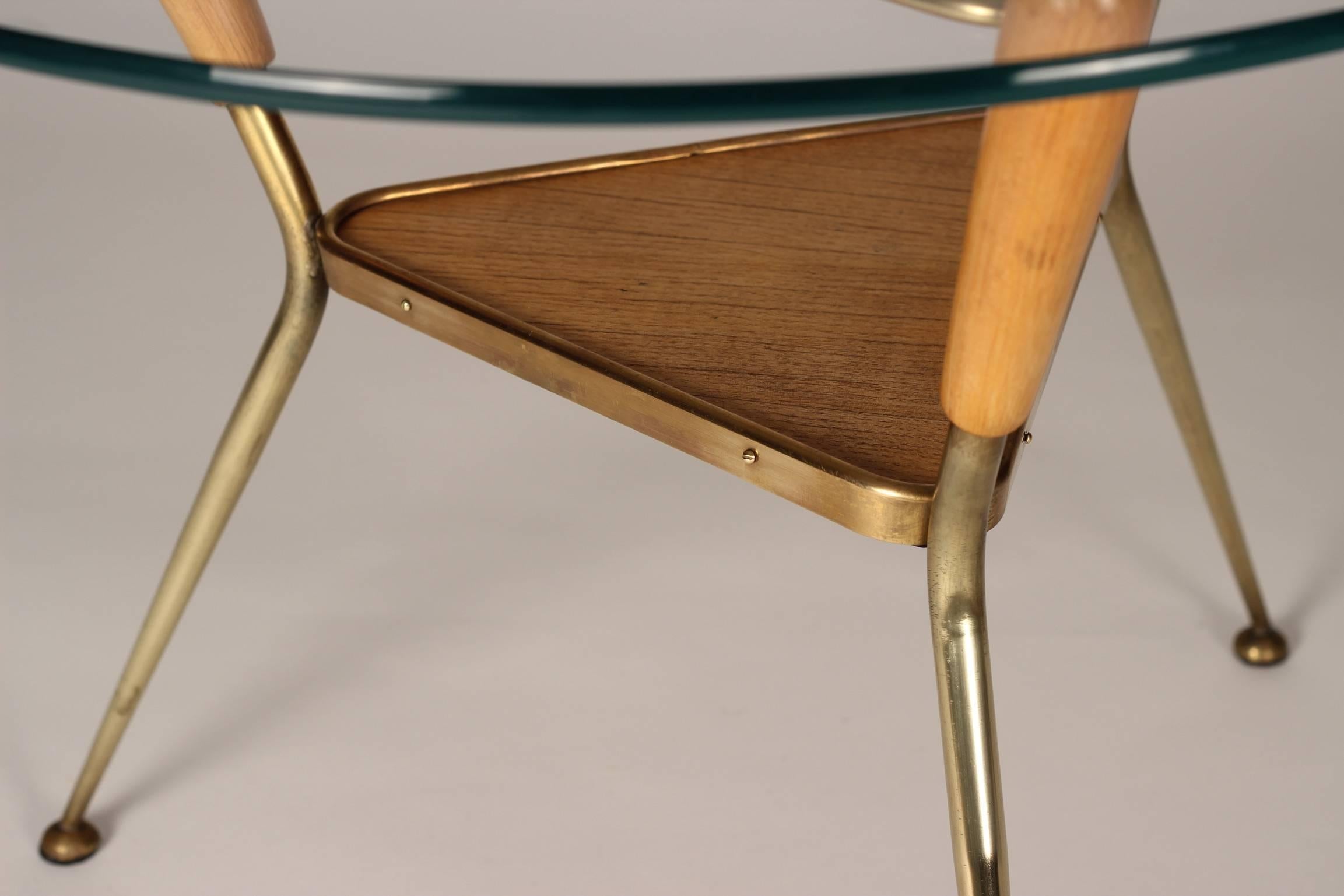 A visually and physically light table, this brass, wood and glass table from the 1960s appears to float with its simplicity of structure. Fully restored with a replacement piece of glass atop and reminiscent of the space exploration of that exciting