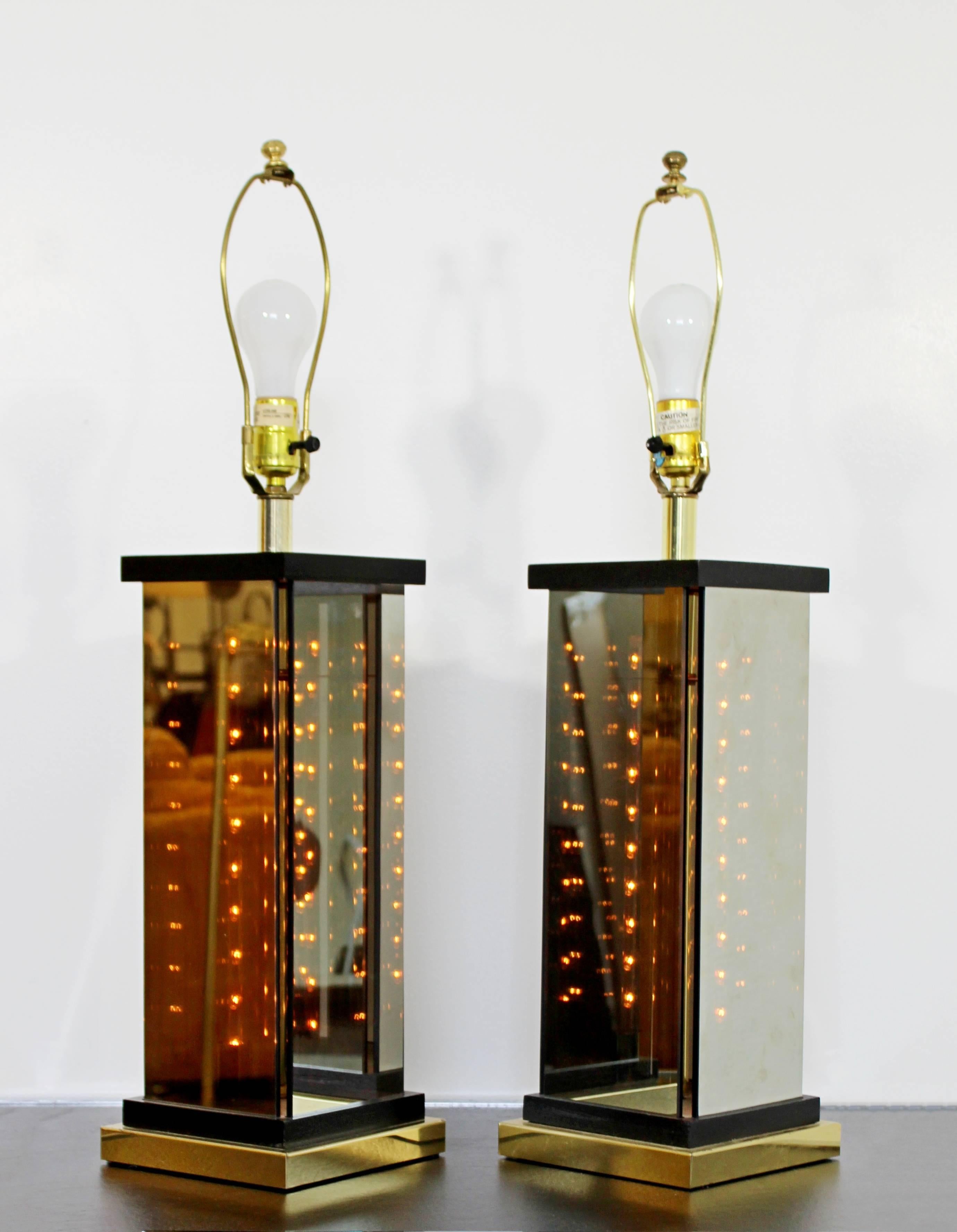 For your consideration is a phenomenal pair of Italian table lamps, made of brass and smoked glass, and the glass bases light up. When the lights are off the glass looks like a mirror and when the lights are on the glass looks smoked. In excellent