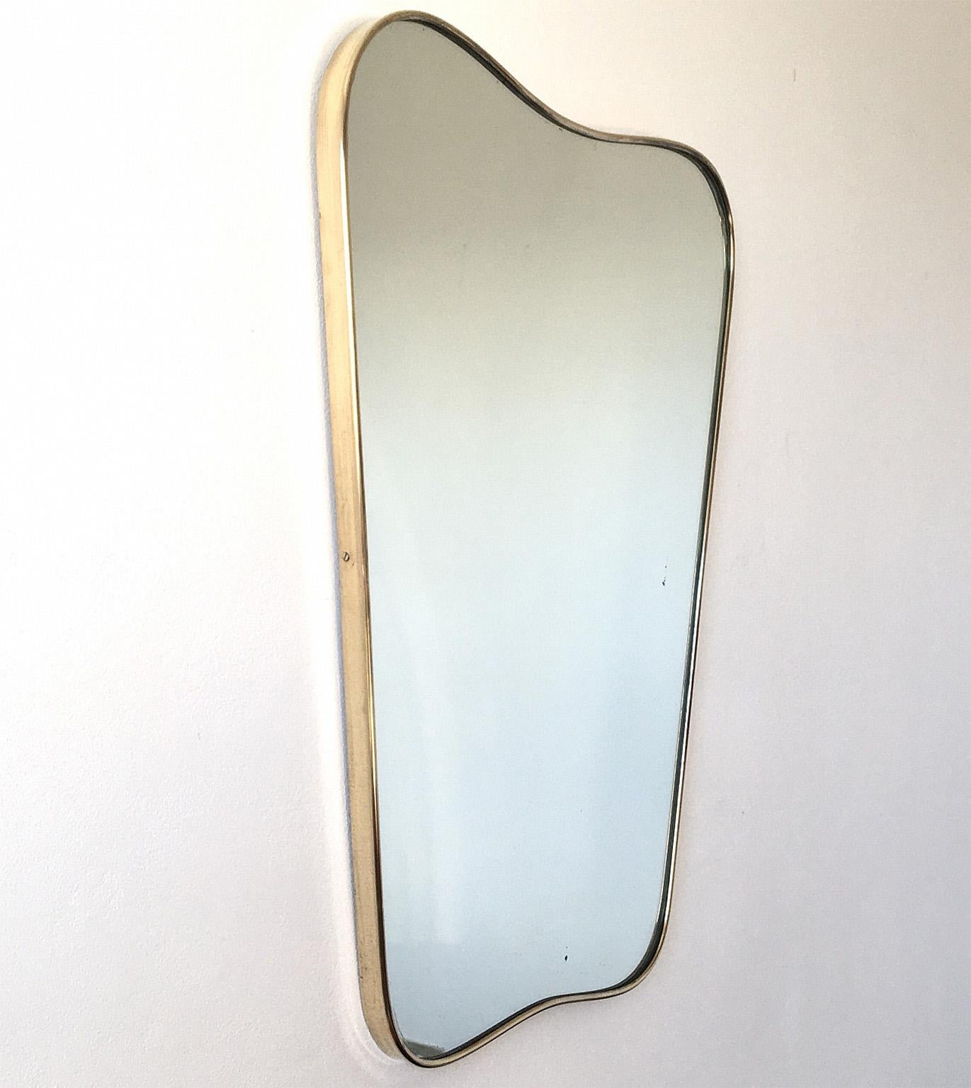 Elegant mirror with Brass frame with typical Gio Ponti sinuos curves and beautiful proportions
Original brass patina, 
Original vintage mirror.