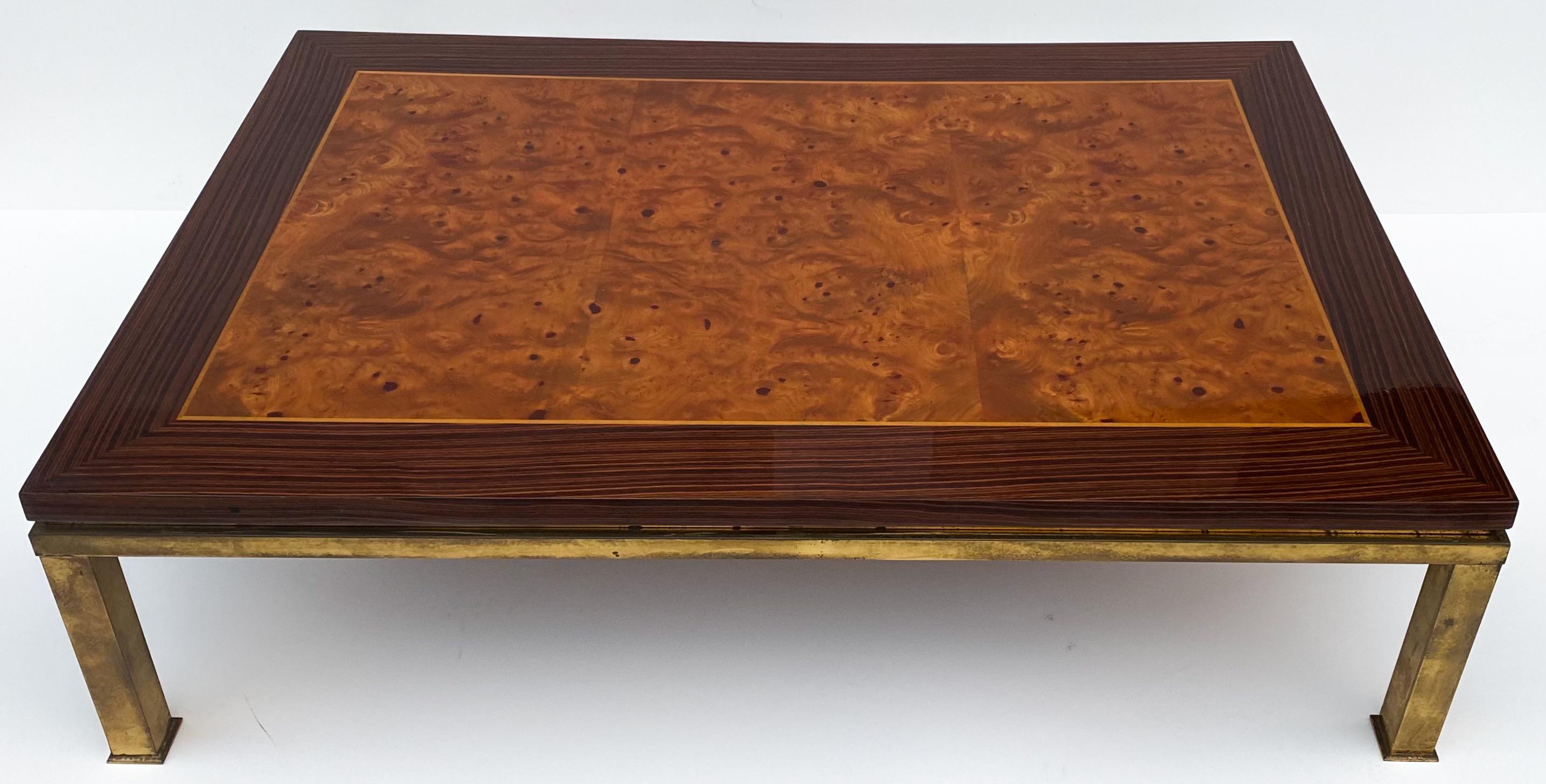 This is a Mid-Century Modern burl wood and brass coffee table with zebra wood banding. The clear coat is a high gloss, and it is in very good condition.