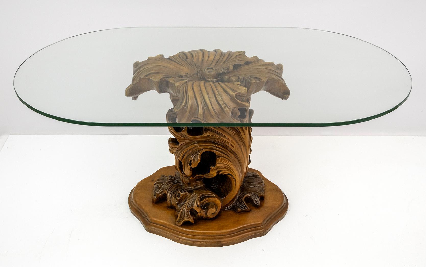 Mid-Century Modern coffee table with carved wooden base, large curls and leaves, 
thick oval shaped crystal top. 1950s.