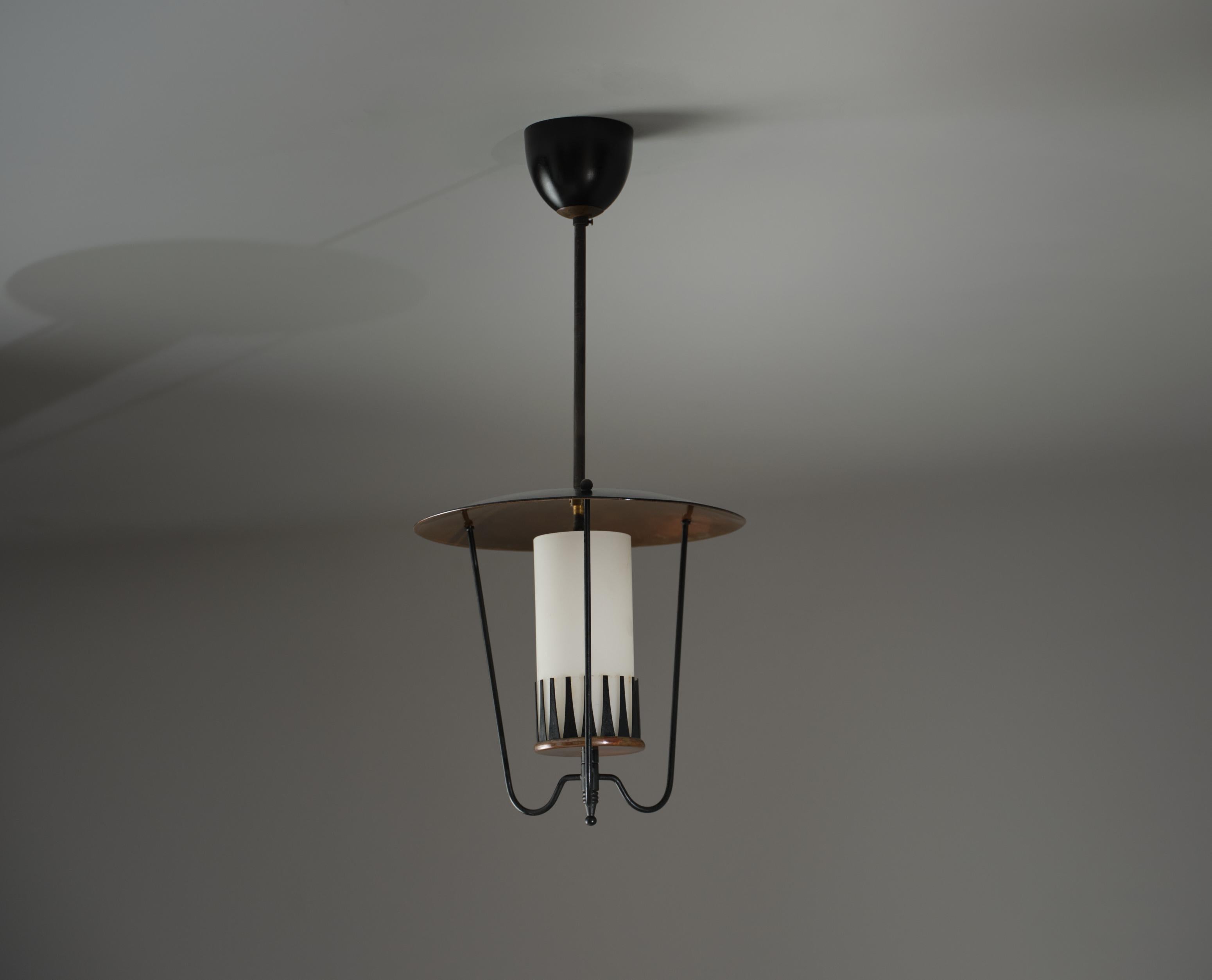 Questo lampadario italiano degli anni '50 combina elegantemente diversi materiali, riflettendo l'etica del design dell'epoca. L'apparecchio presenta un cappello completamente in bronzo che completa un baldacchino parzialmente in bronzo, collegato da