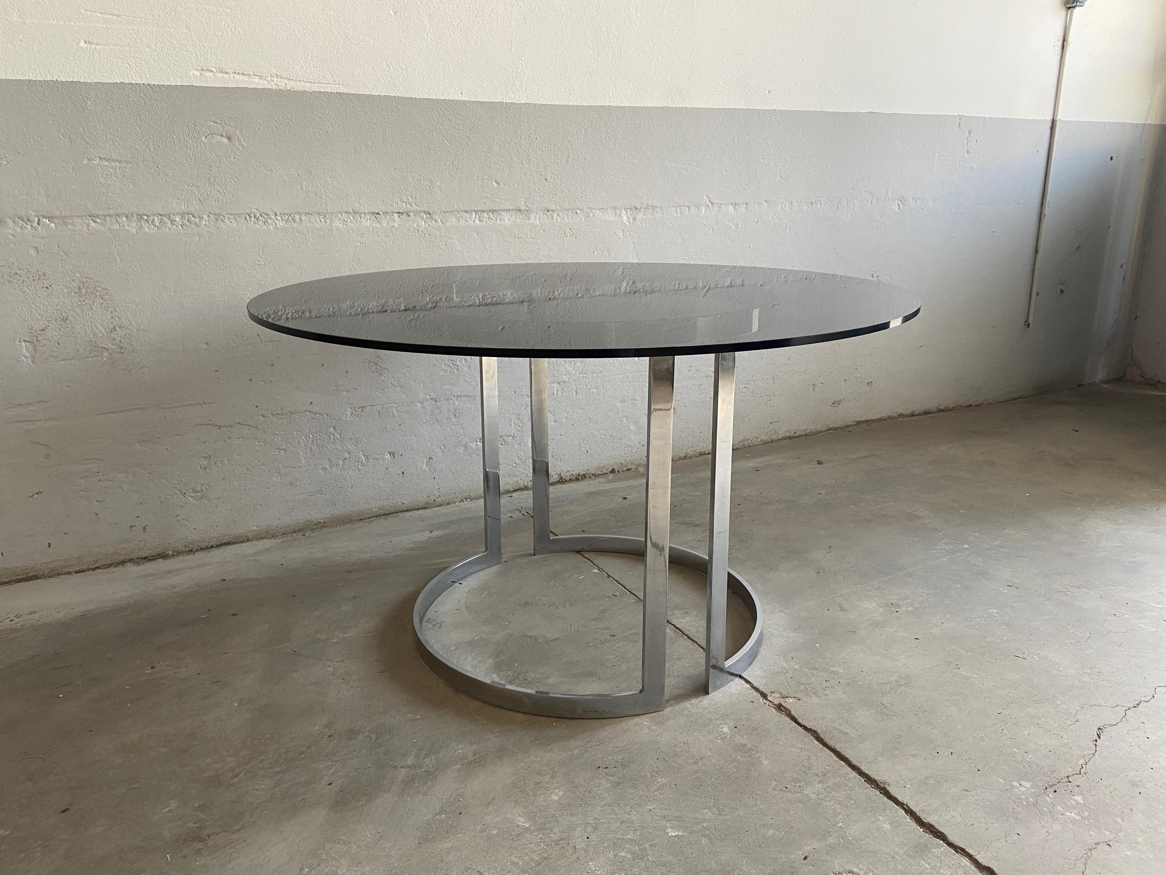 Table de salle à manger ou de centre chromée italienne du milieu du siècle avec plateau rond en verre fumé dans le style de Milo Baughman.
La table est en très bon état.
 