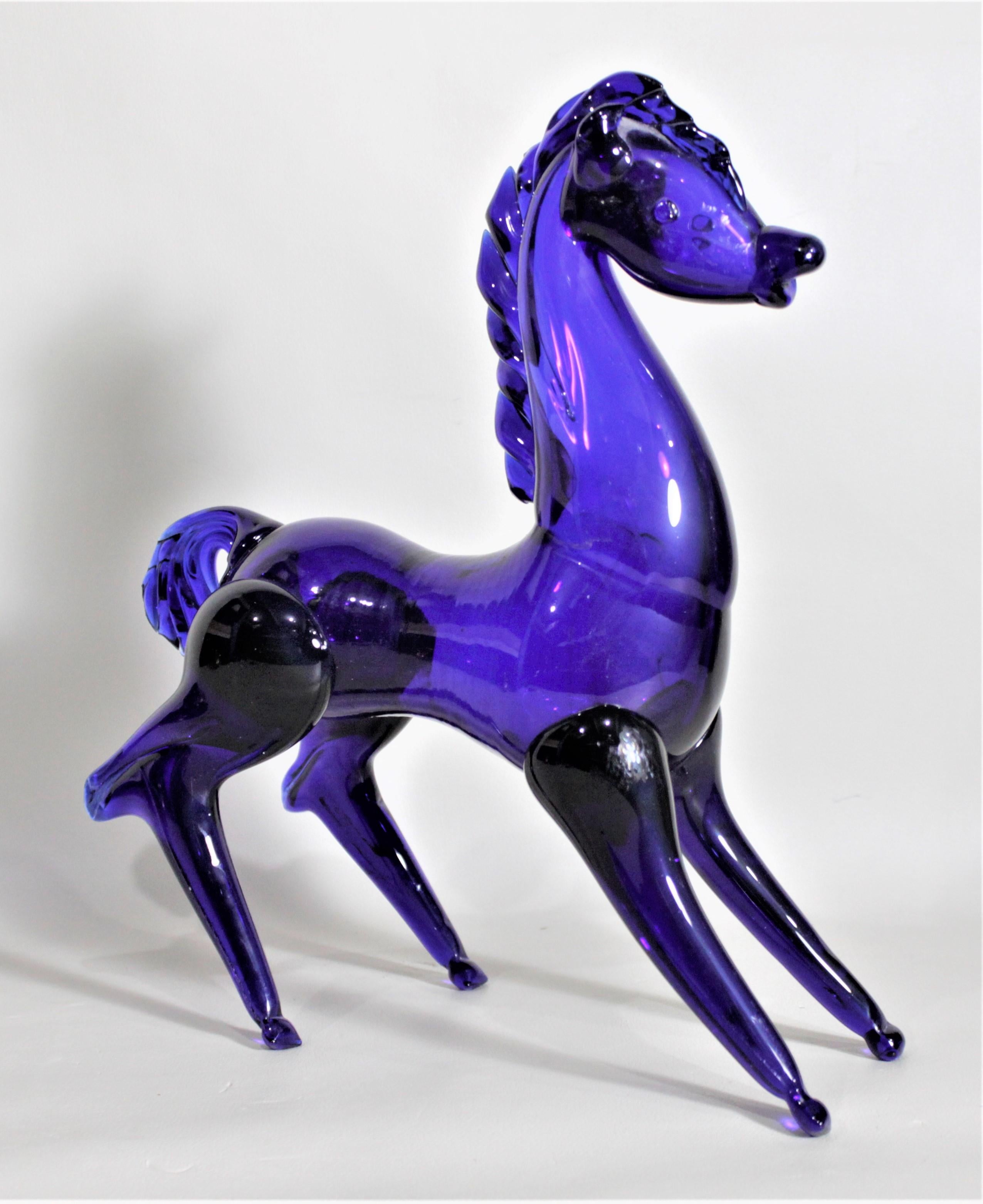 This very well executed stylized horse figurine is presumed to have been made in Italy by any one of a number the Murano glass artists during the 1960s in the period Mid-Century Modern style. The horse is done in a deep cobalt blue and portrays a