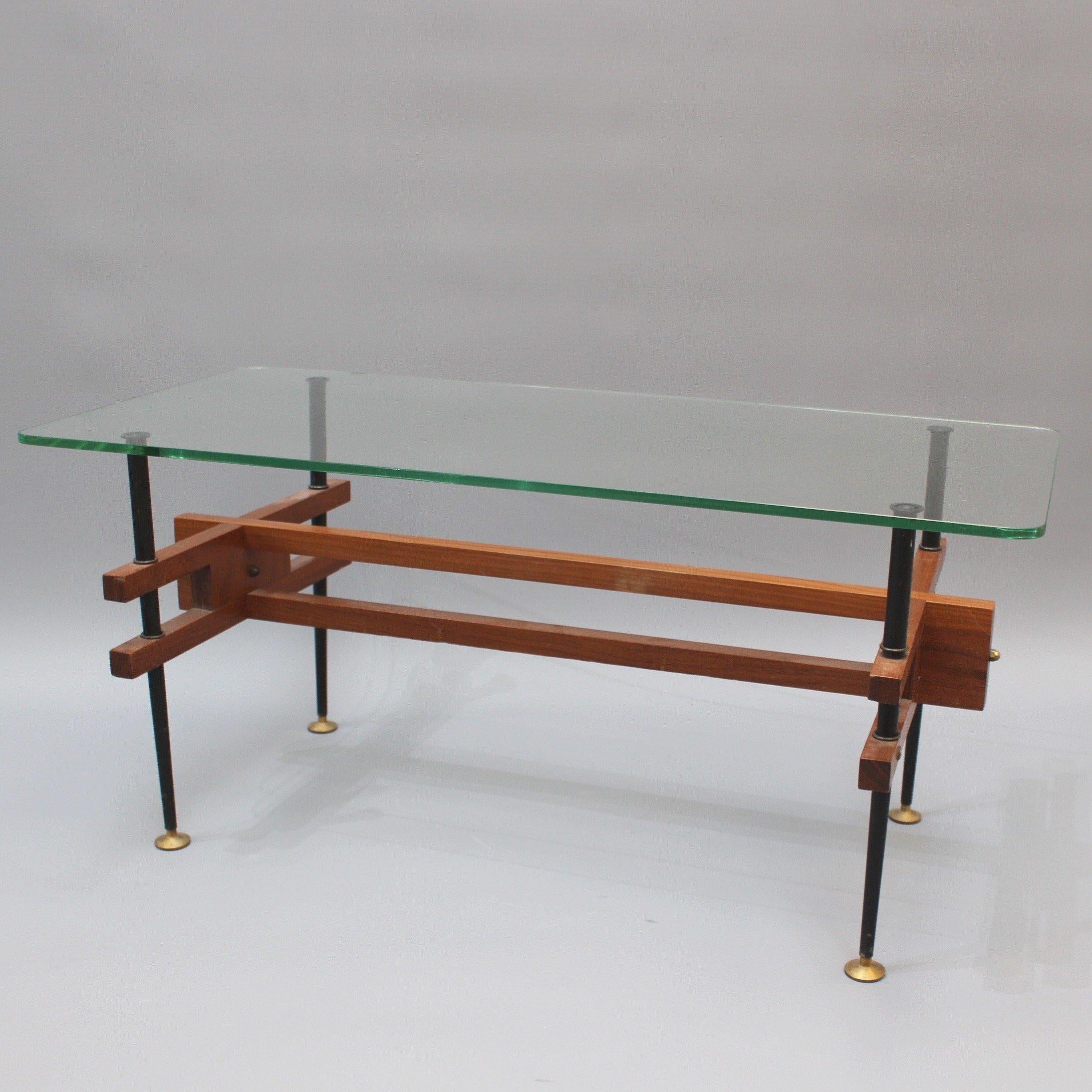 Mid-century modern Italian coffee table (circa 1960s). This is a delightful, light weight modern table with removable glass top and wooden frame. The wooden frame consists of an elongated piece and two H-frame cross-supports which attach to the