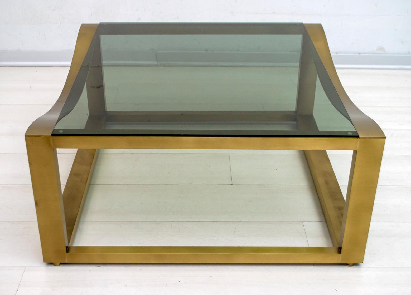 Cette table basse a été produite dans les années 70 en Italie, avec un design très raffiné, en laiton massif et verre fumé.