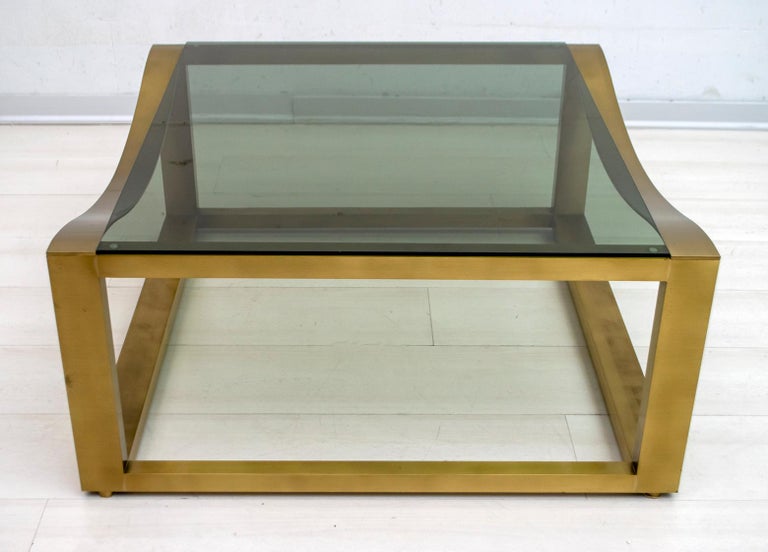 This coffee table was produced in the 70s in Italy, with a very refined design, in solid brass and smoked glass.