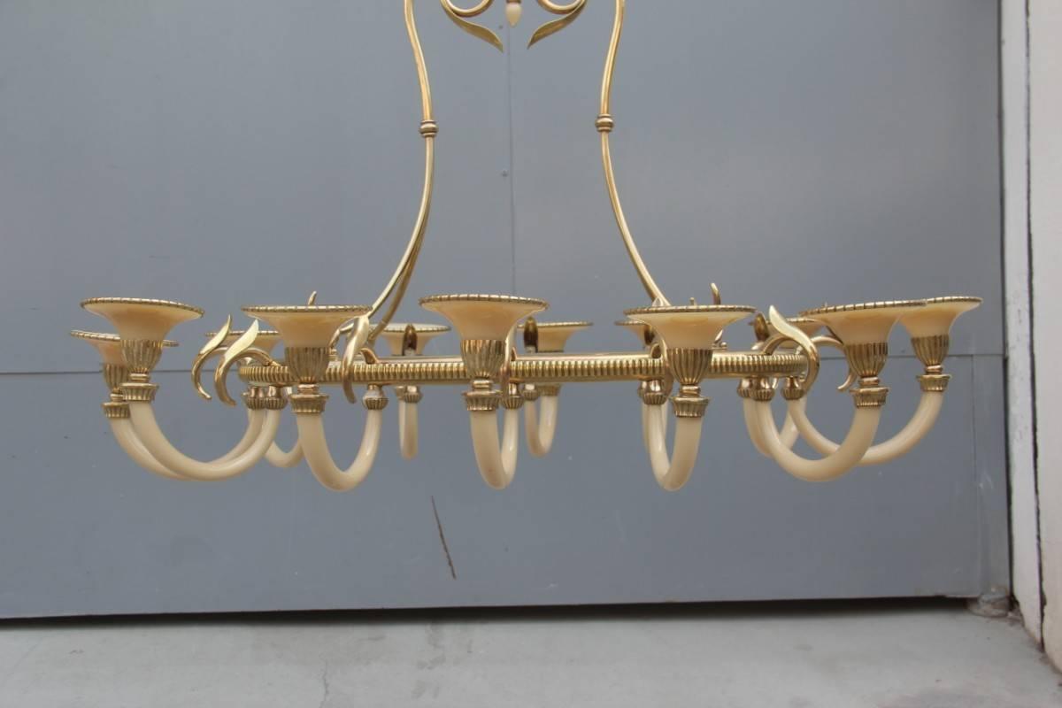Spectacular and articulate midcentury Italian design chandelier, made entirely by hand by masters now instincts, brass sculptures make it a work of art of considerable value and preciousness, then the addition of opal glass makes it sinuous and