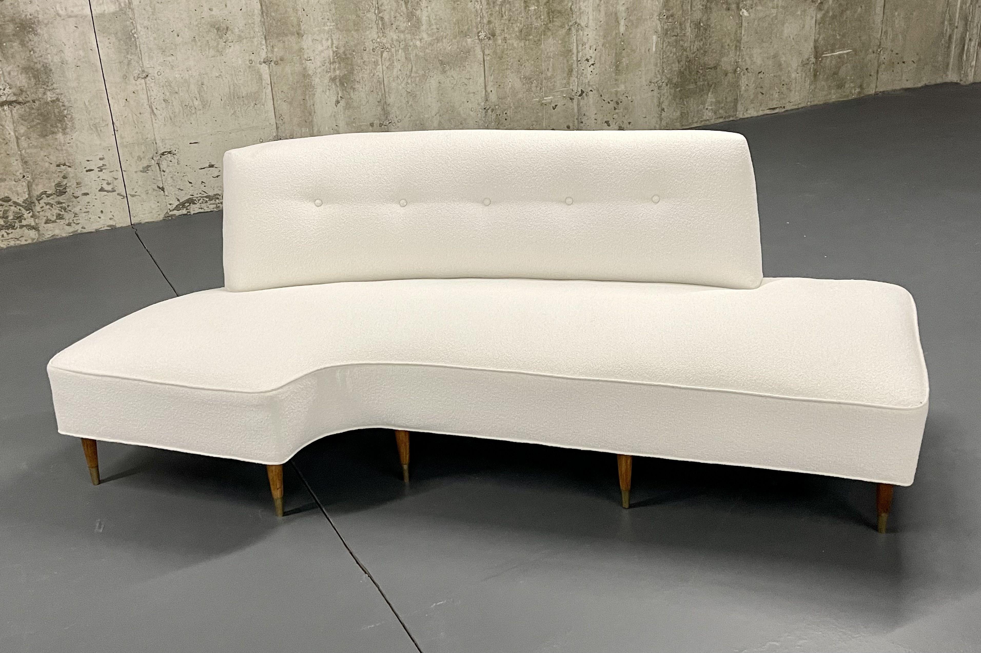 Mid-Century Modern Italian designer corner/curved sofa, chaise lounge, bouclé.

Curved freeform, organic shape sofa, settee, loveseat or chaise lounge having a newly upholstered white Bouclé upper sitting on walnut legs with brass