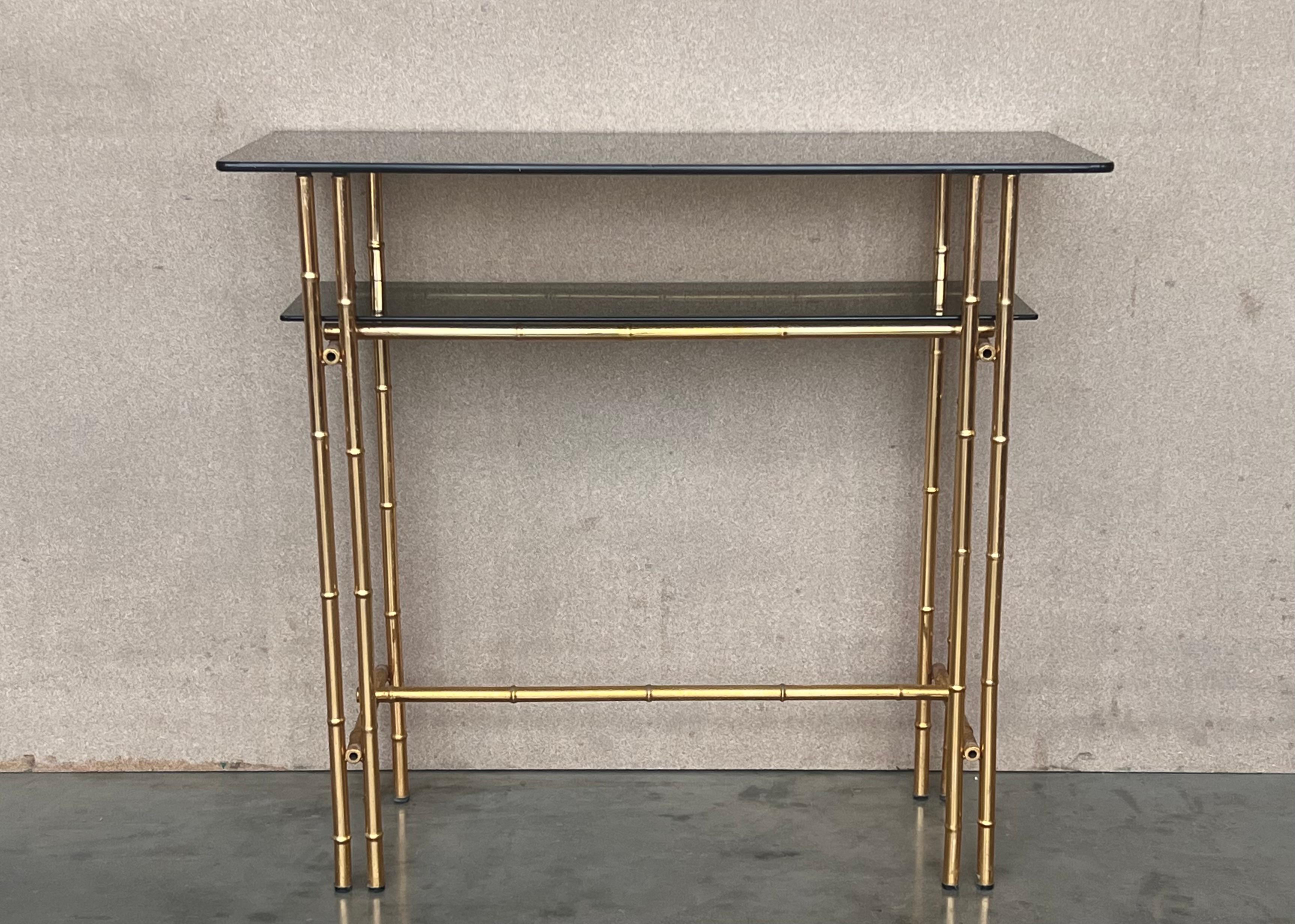 Mid-Century Modern Italian faux bamboo gilt metal console table or vanity with smoked glass.

Measures: Total height: 32in
Height to the middle low shelve: 25.78in
