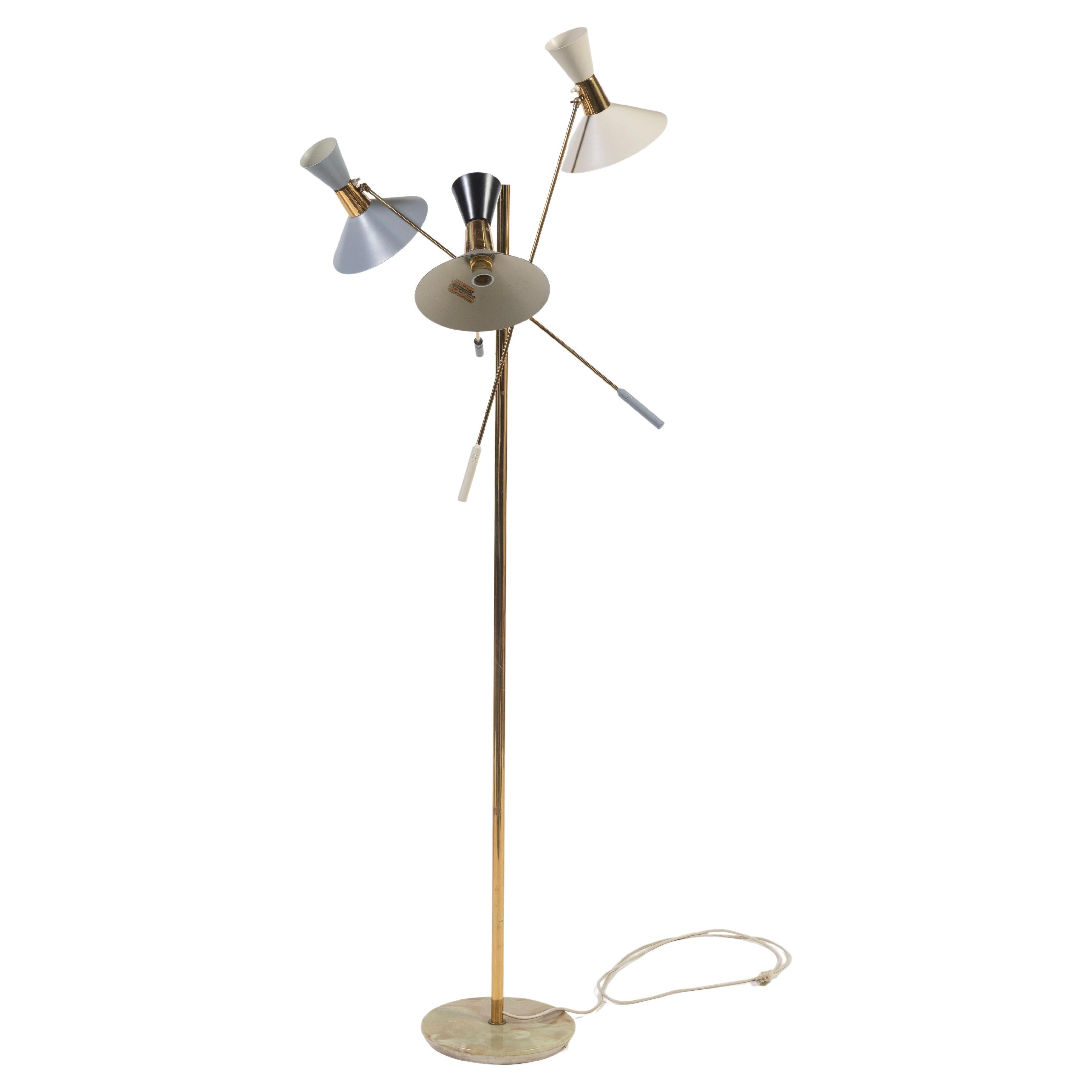 A favorite among lovers of Mid-Century Modern design, this iconic floor lamp is in very good condition. Made in Italy by G.C.M.E. (label visible in photos), the fixture has three adjustable brass arms, and three lacquered aluminum shades in black,