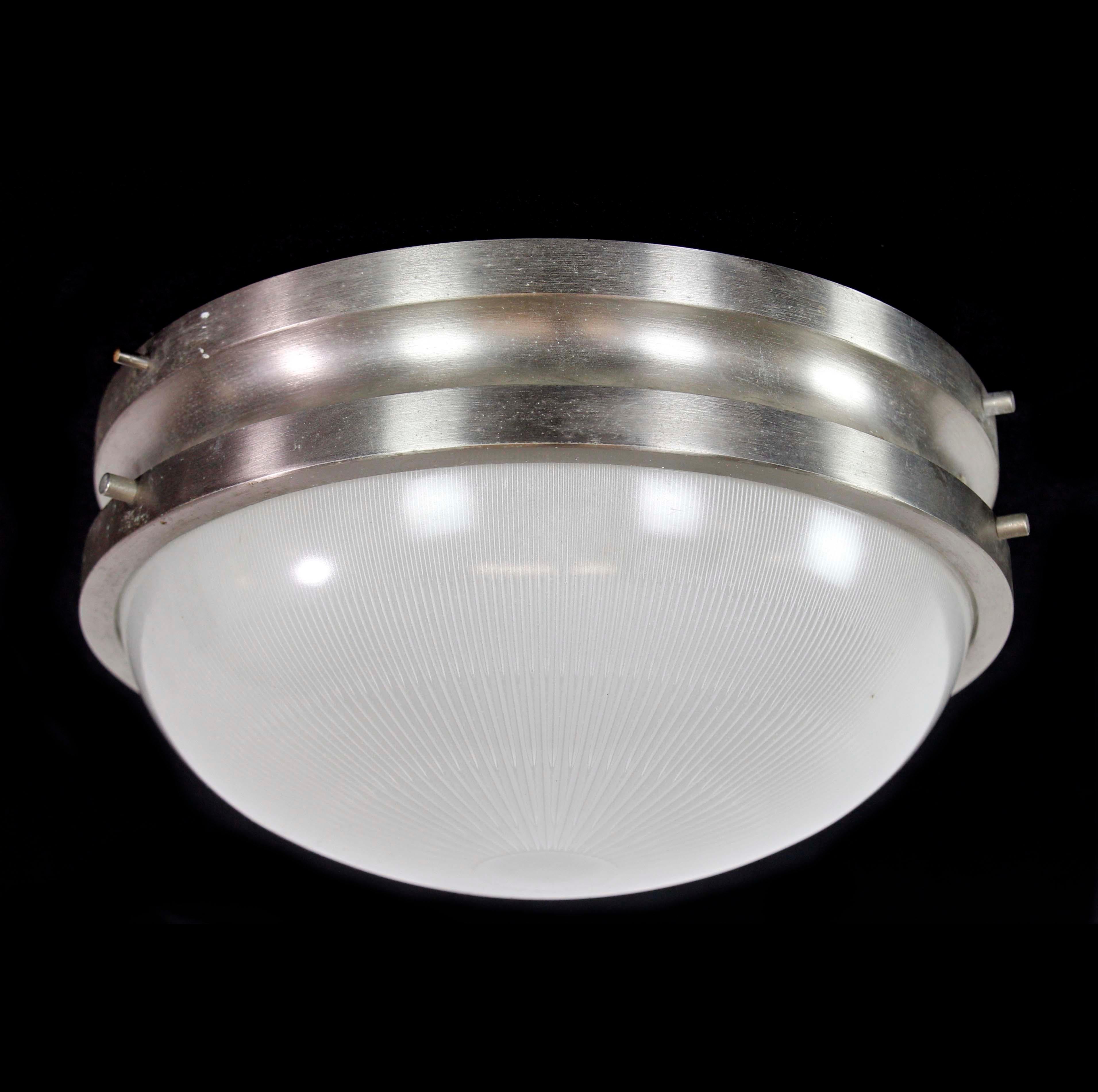 This Italian flush ceiling light encapsulates Mid-Century Modern aesthetics. Crafted from aluminum and glass, it embodies the innovative design of that era. This flush mount ceiling light adds a touch of charm to spaces, blending artistic ingenuity