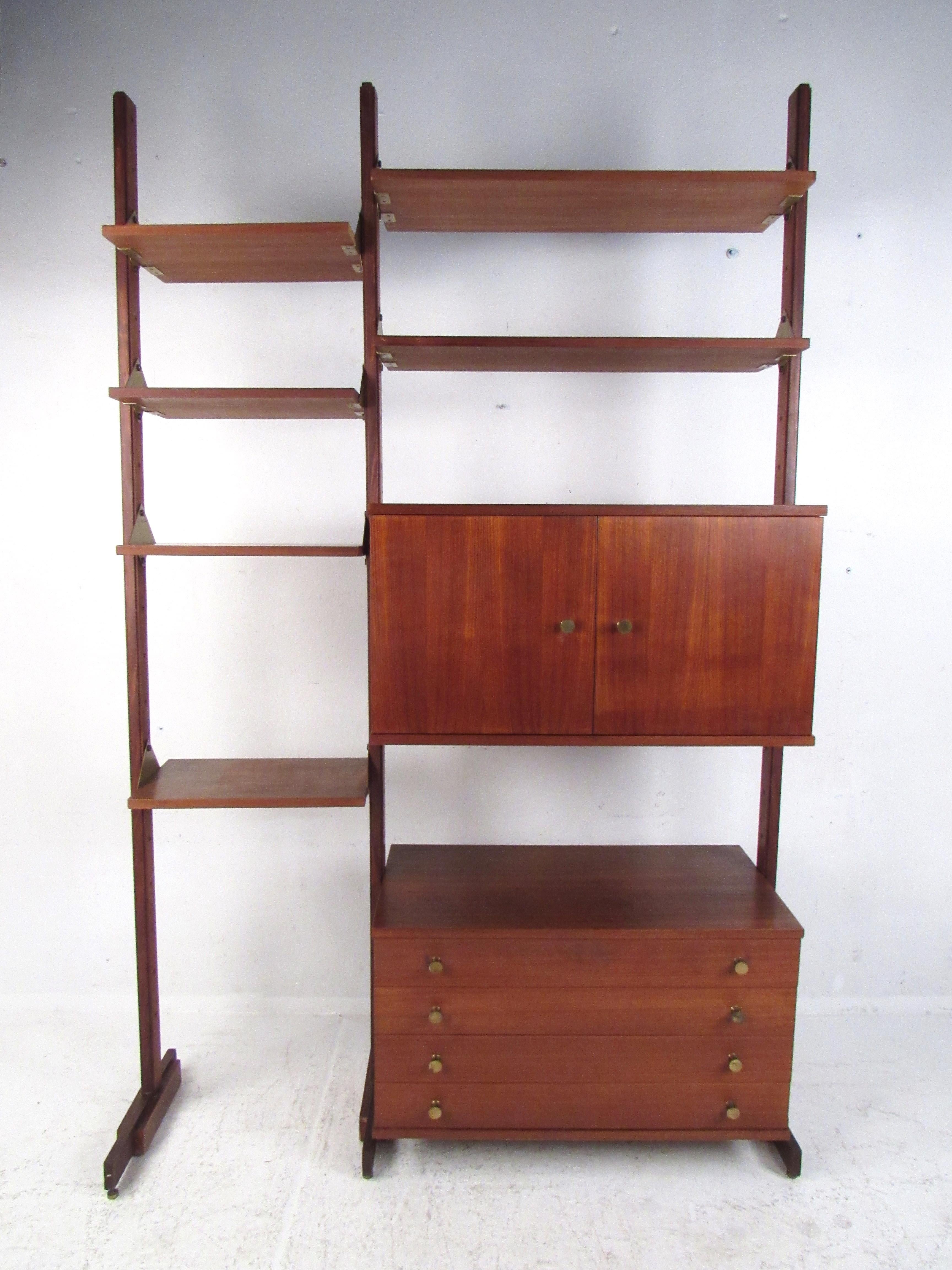 An impressive vintage Italian shelving unit that devotes one side entirely to displaying items on shelves while the other side offers storage options. Quality construction with a rich walnut finish, adjustable feet levelers, and brass handles. The