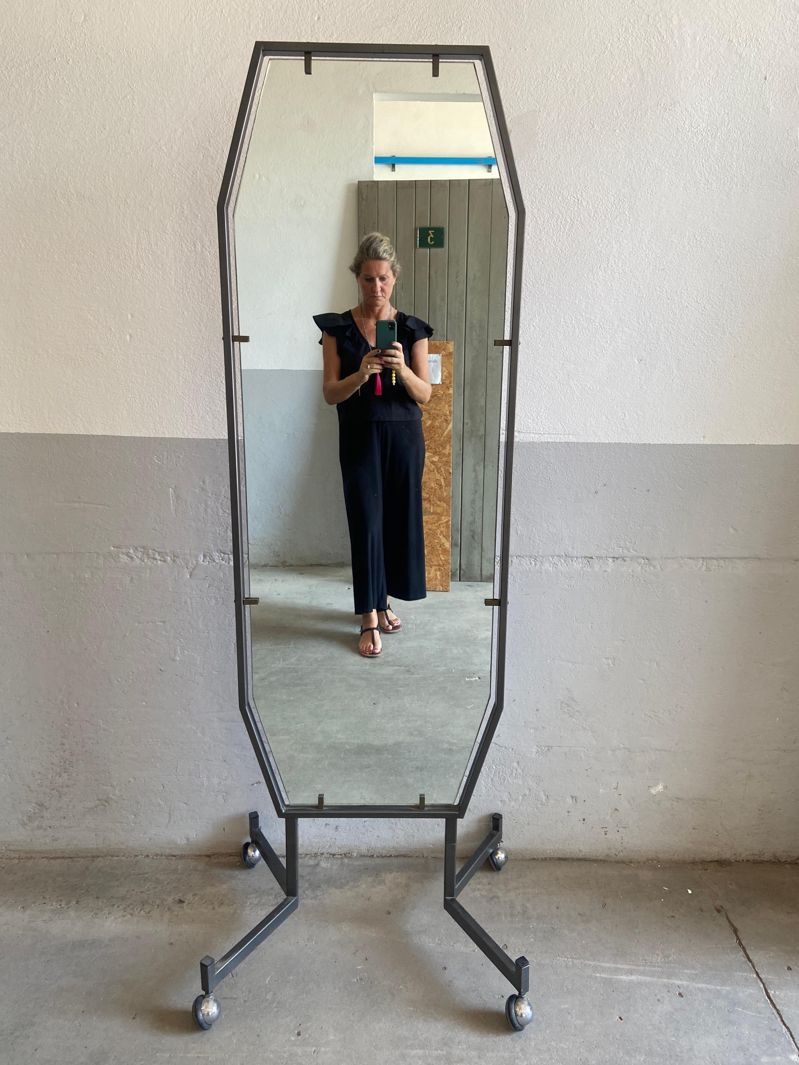 20th century Italian full length mirror with black painted metal frame and legs on wheels. 1970s.