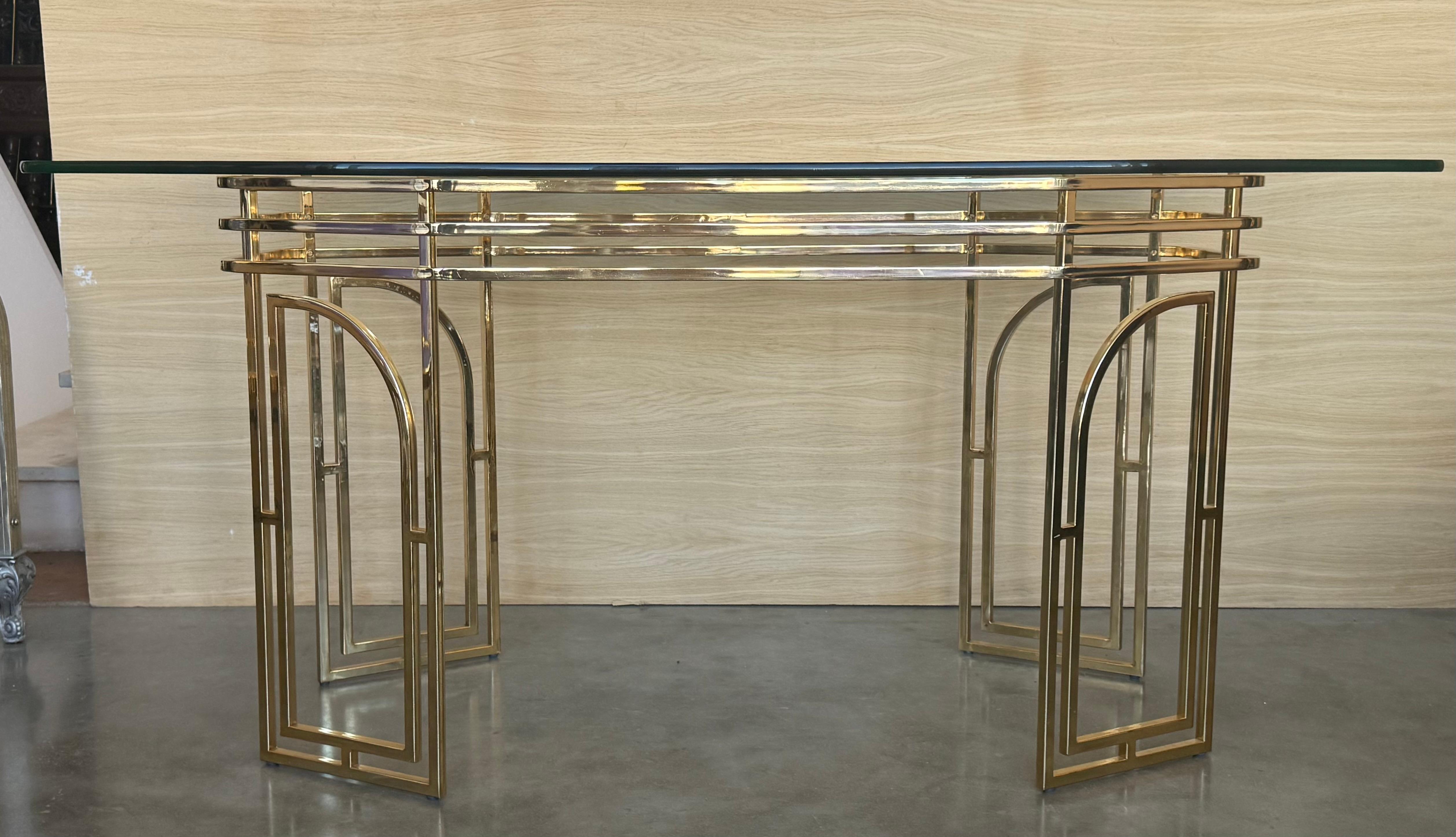 Table de salle à manger vintage géométrique moderniste en métal doré ( laiton ) et verre clair 1970 Italie. Une fabuleuse table dans le style de Romeo Rega se compose d'un cadre doré avec quatre piédestaux de chaque côté,
L'état vintage est très bon