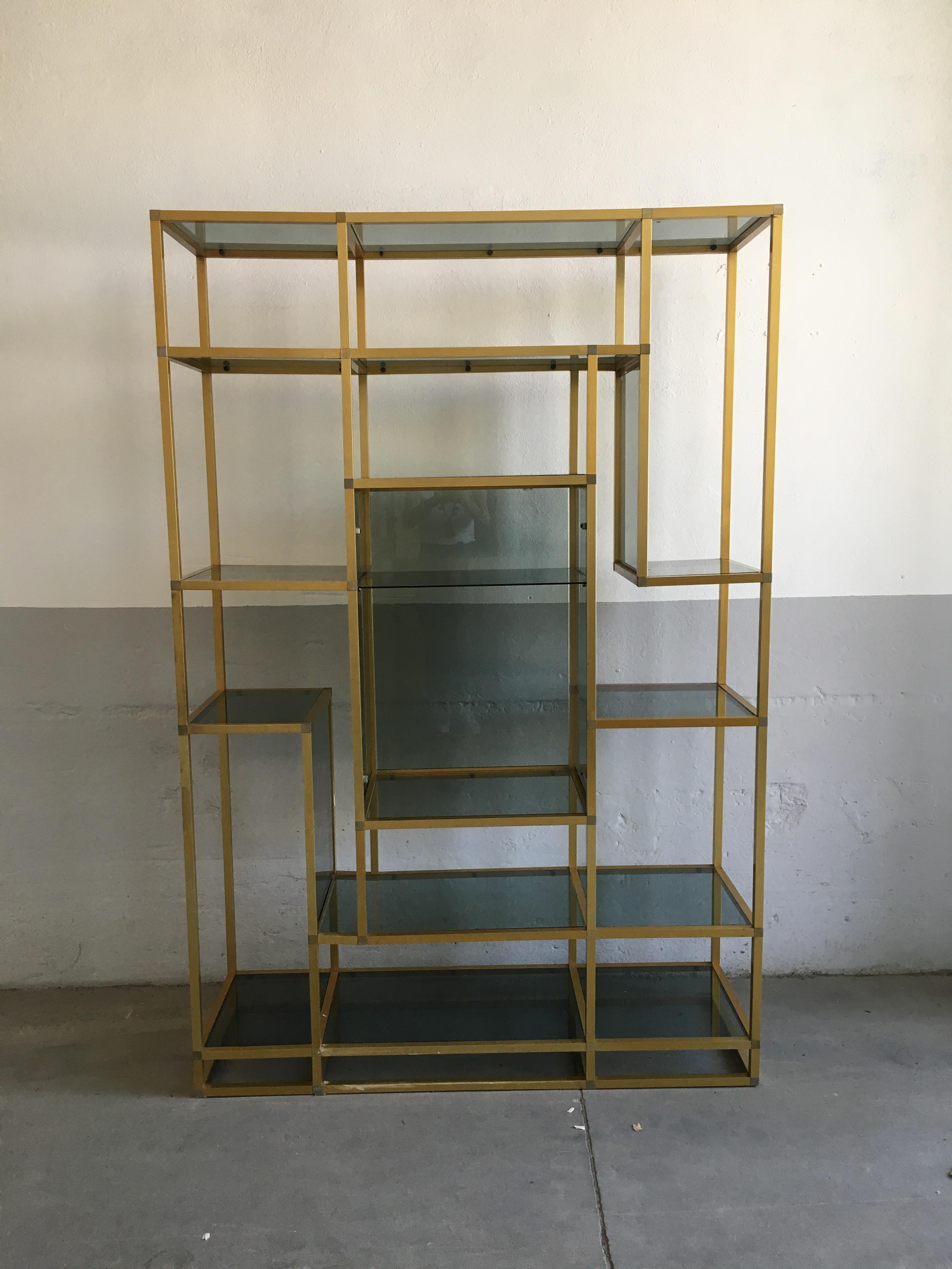 Moderne italienische Etagere aus vergoldetem Aluminium oder Bücherregal aus der Jahrhundertmitte mit Ablagen aus Rauchglas.
Der zentrale Teil des Bücherregals ist mit einem Fach ausgestattet, das durch eine Rauchglastür zugänglich ist, wie auf den