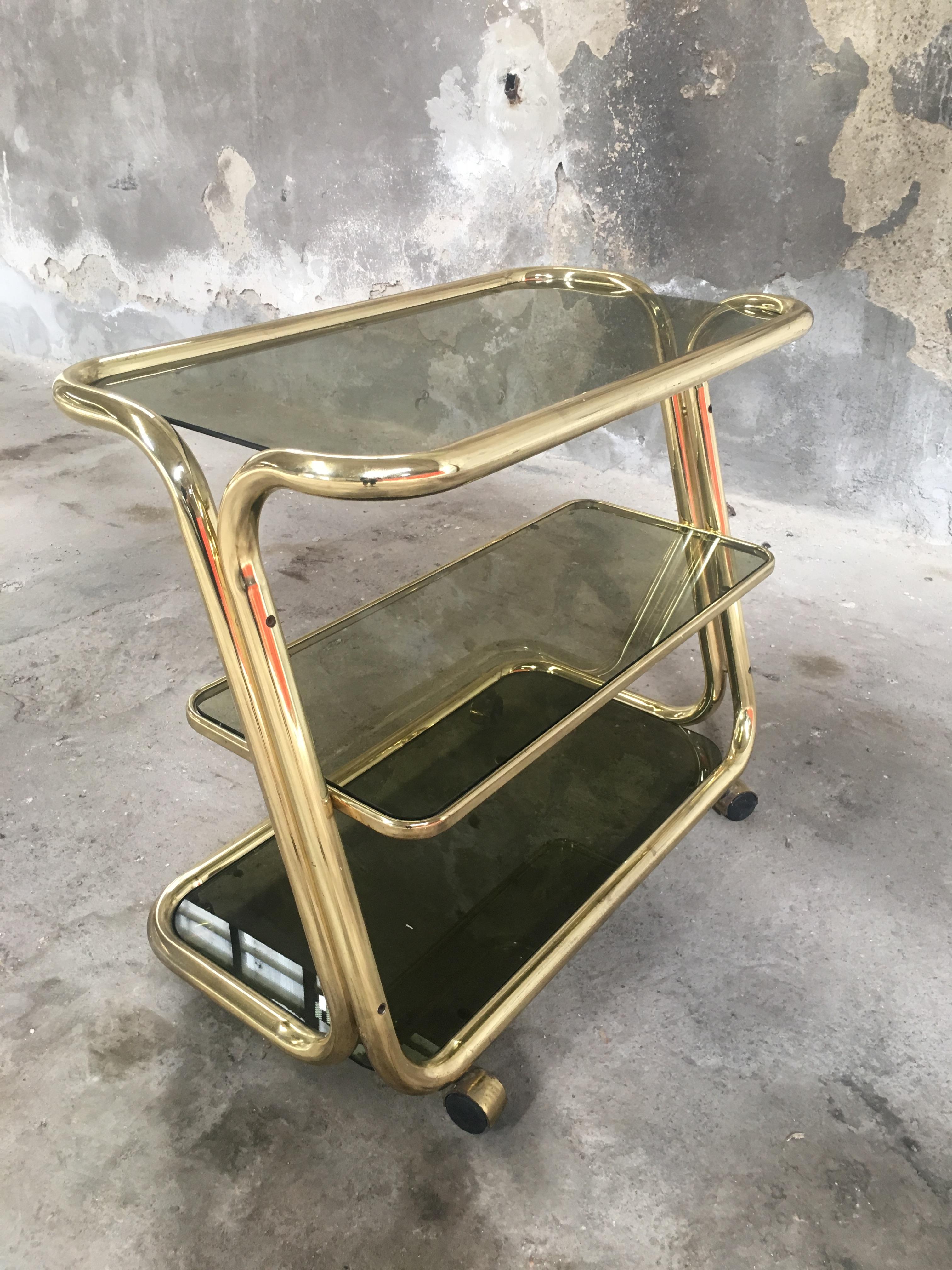 Mid-Century Modern Italian gilt metal bar cart or étagère on wheels with smoked glass shelves.