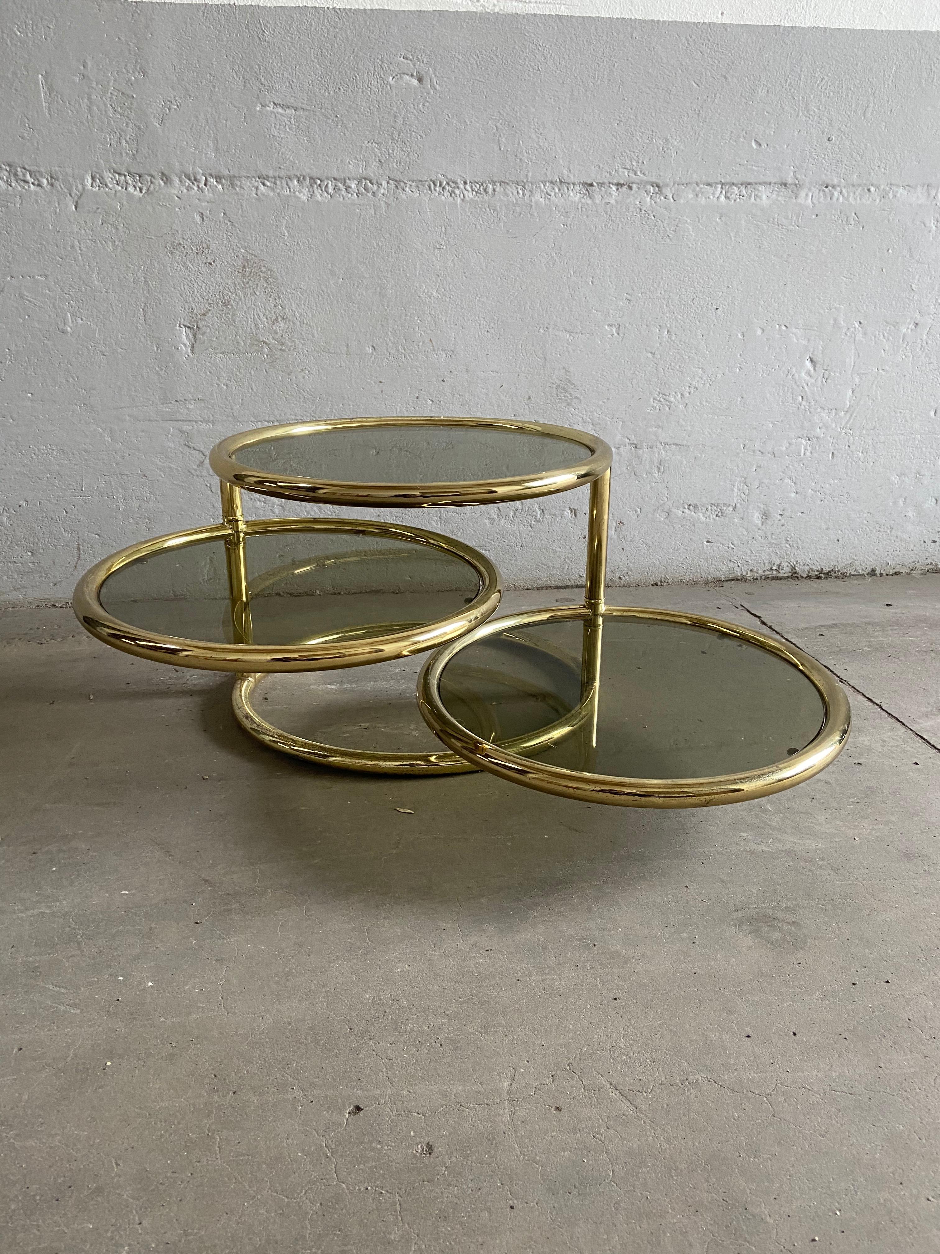 Mid-Century Modern Italian gilt metal round coffee or side table with two adjustable smoked glass shelves, 1970s.