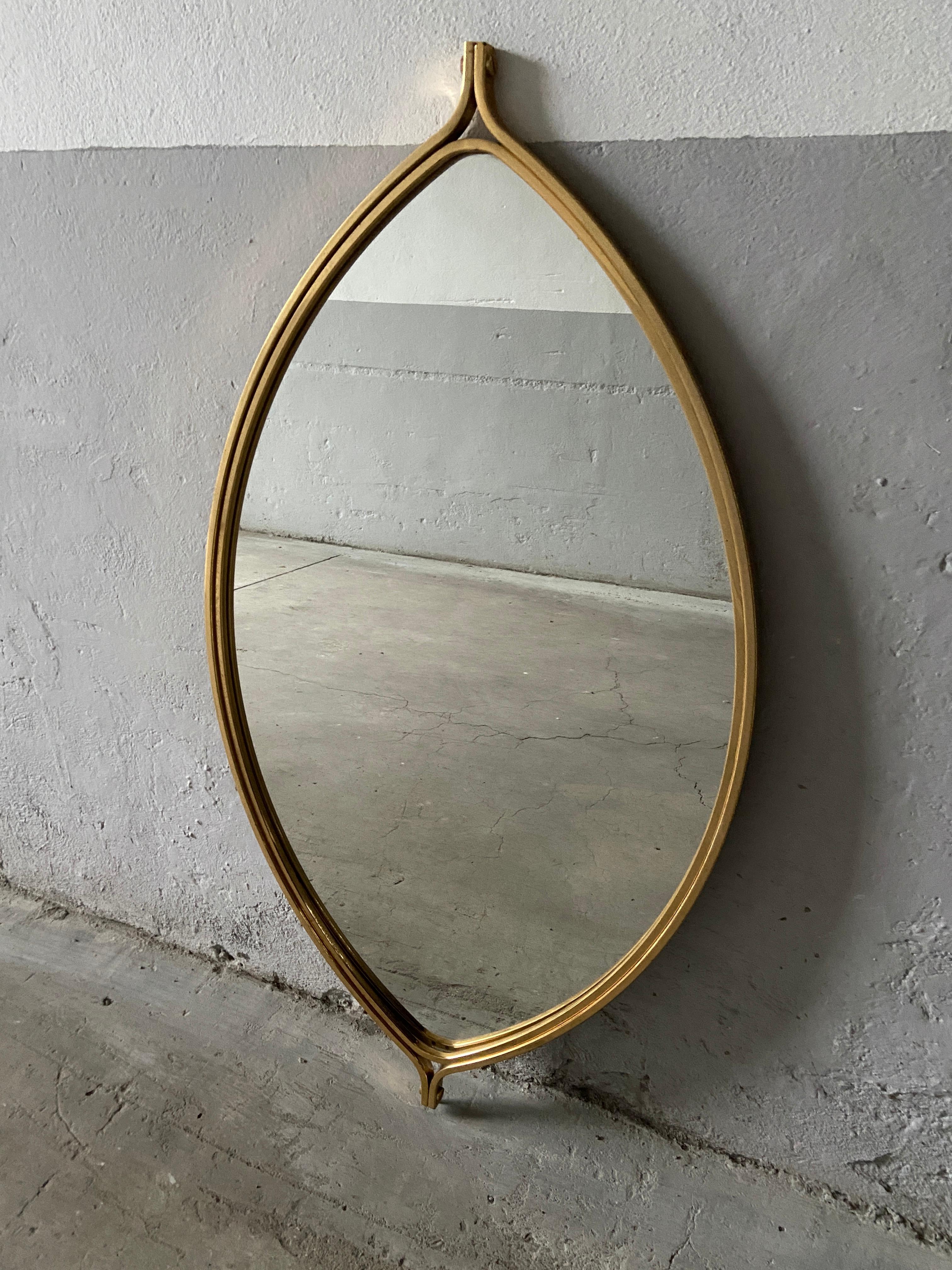 Mid-Century Modern Italian gilt metal eye shaped wall mirror.
The mirror has a loop to be hung vertical, but it can be easily hung horizontal.