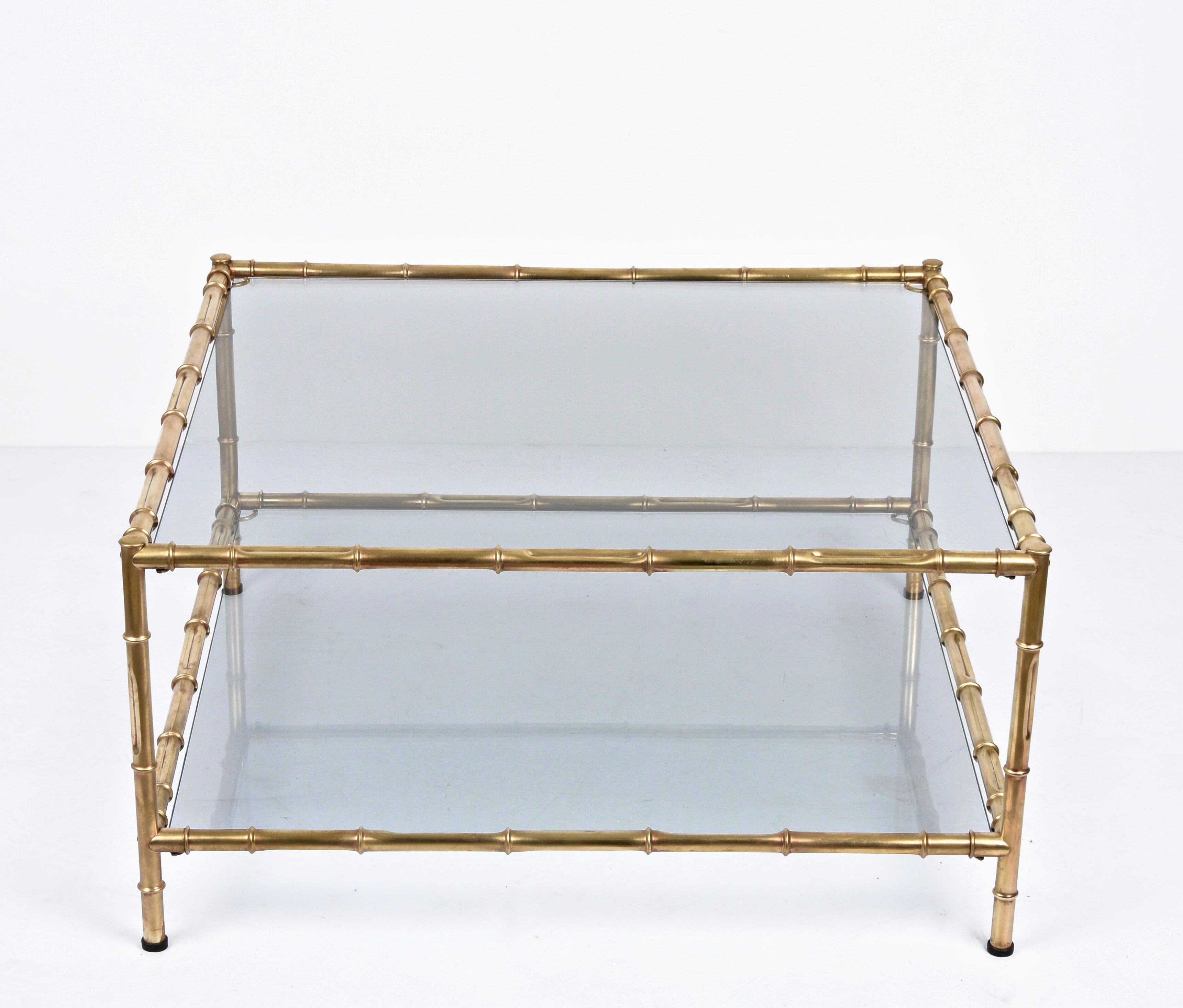 Amazing midcentury modern rectangular coffee table in brass faux bamboo with two-tiers glass tops. This fantastic piece was produced in Italy during the 1970s.

A luxurious item with a bamboo-shaped structure made of brass and two layers of smoked