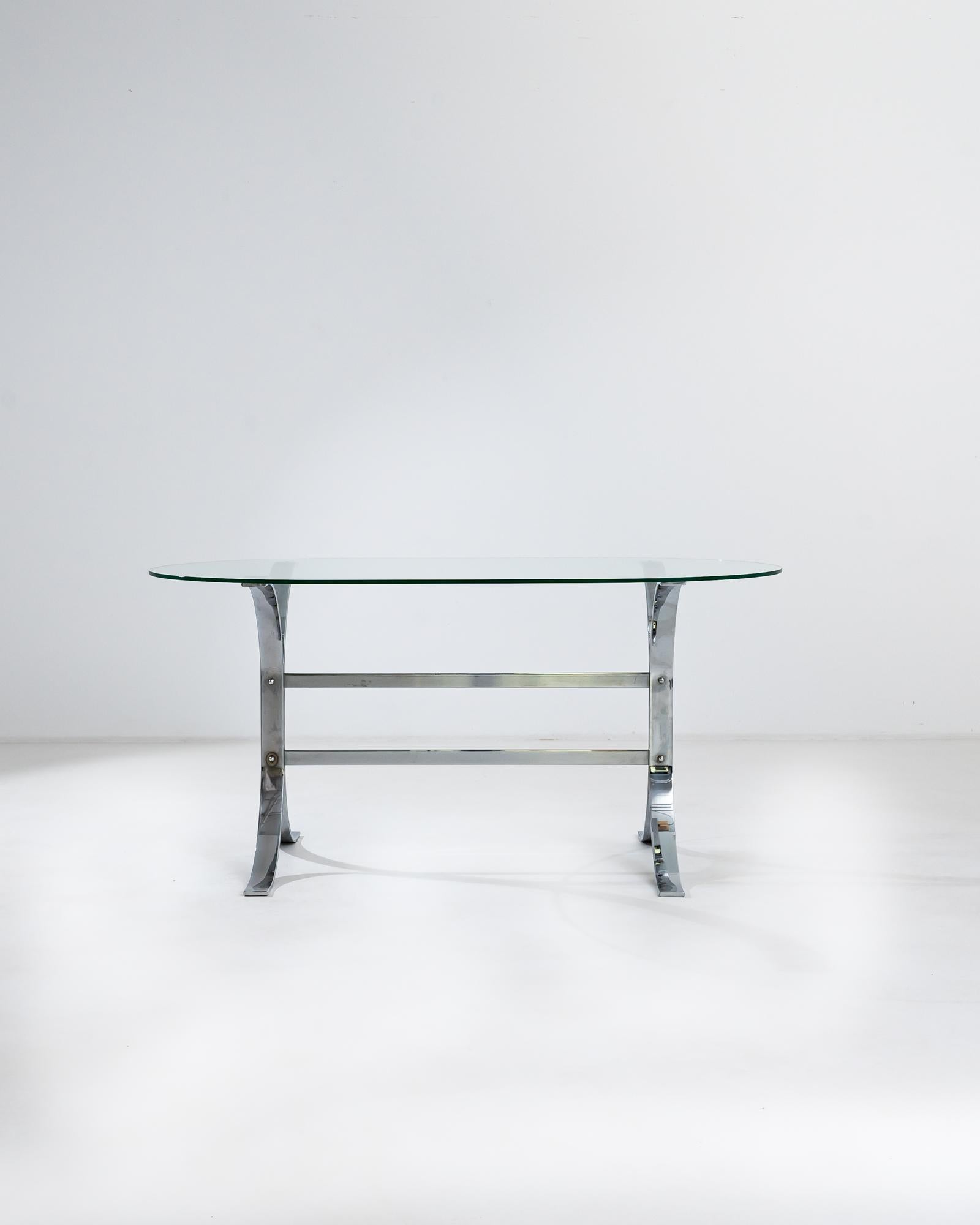 A 20th century Italian dining table made from metal with a glass top. This trestle table is constructed of thick, bent metal bars and exposed hardware, creating a symmetrical composition with brutalist charm. Industrial in its conception, though