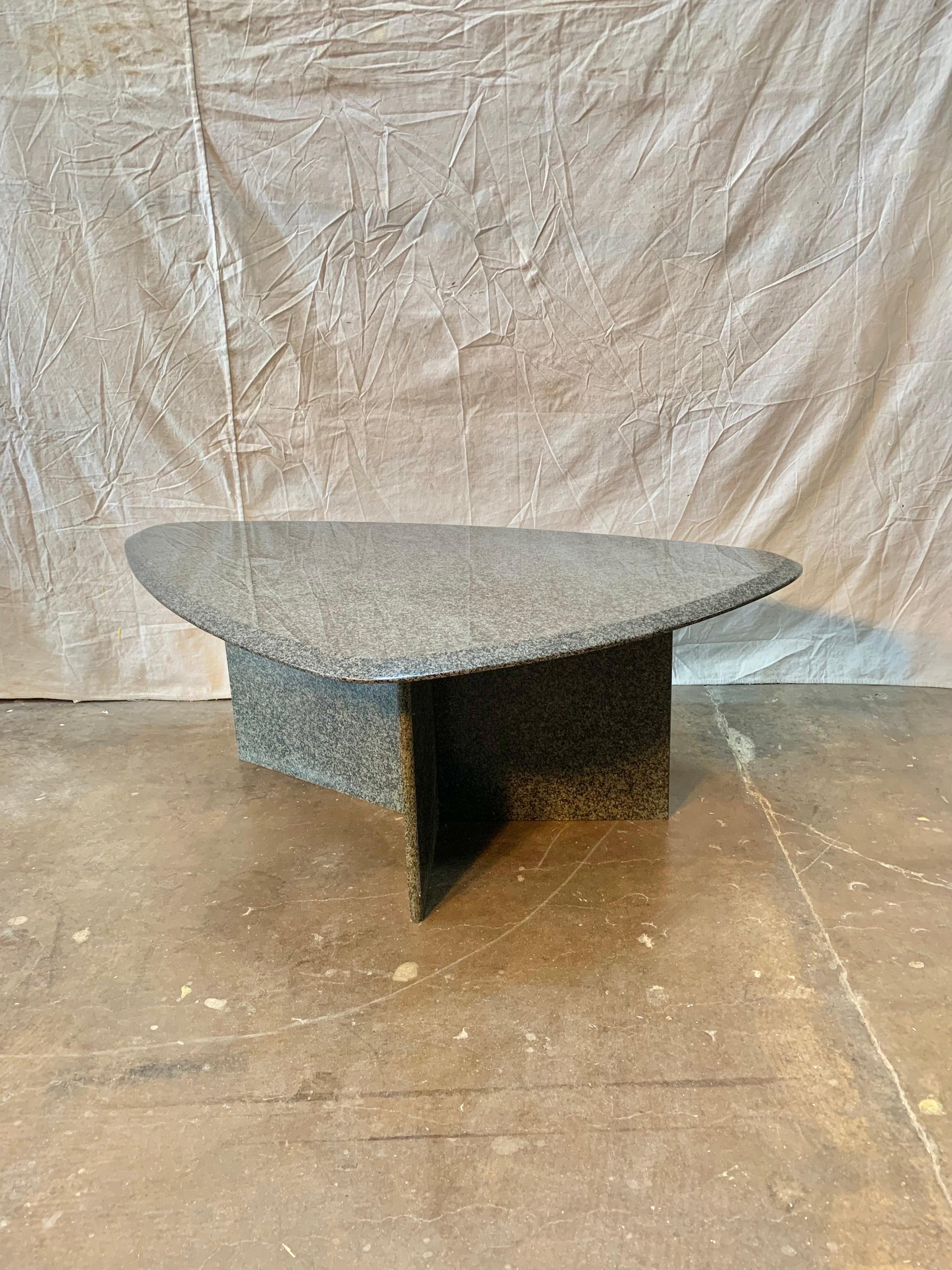 Found in the South of France, this Mid Century Modern Italian coffee table is made of granite with specs of black and multiple greys. The beveled top is triangular in shape and is attached to a 