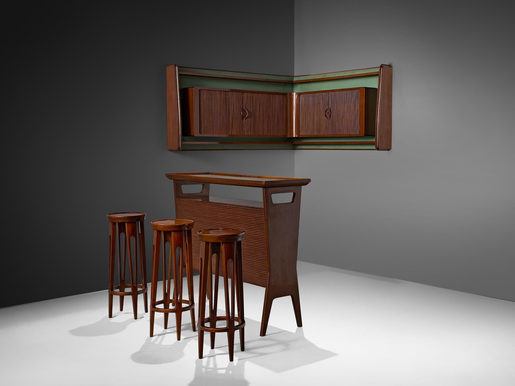 Ensemble de bar comprenant un meuble mural, un élément de comptoir et un ensemble de trois tabourets de bar, noyer, métal, Italie, années 1950 

Bar privé élégant et ludique avec unité murale et tabourets assortis. Un ensemble divin au cœur de