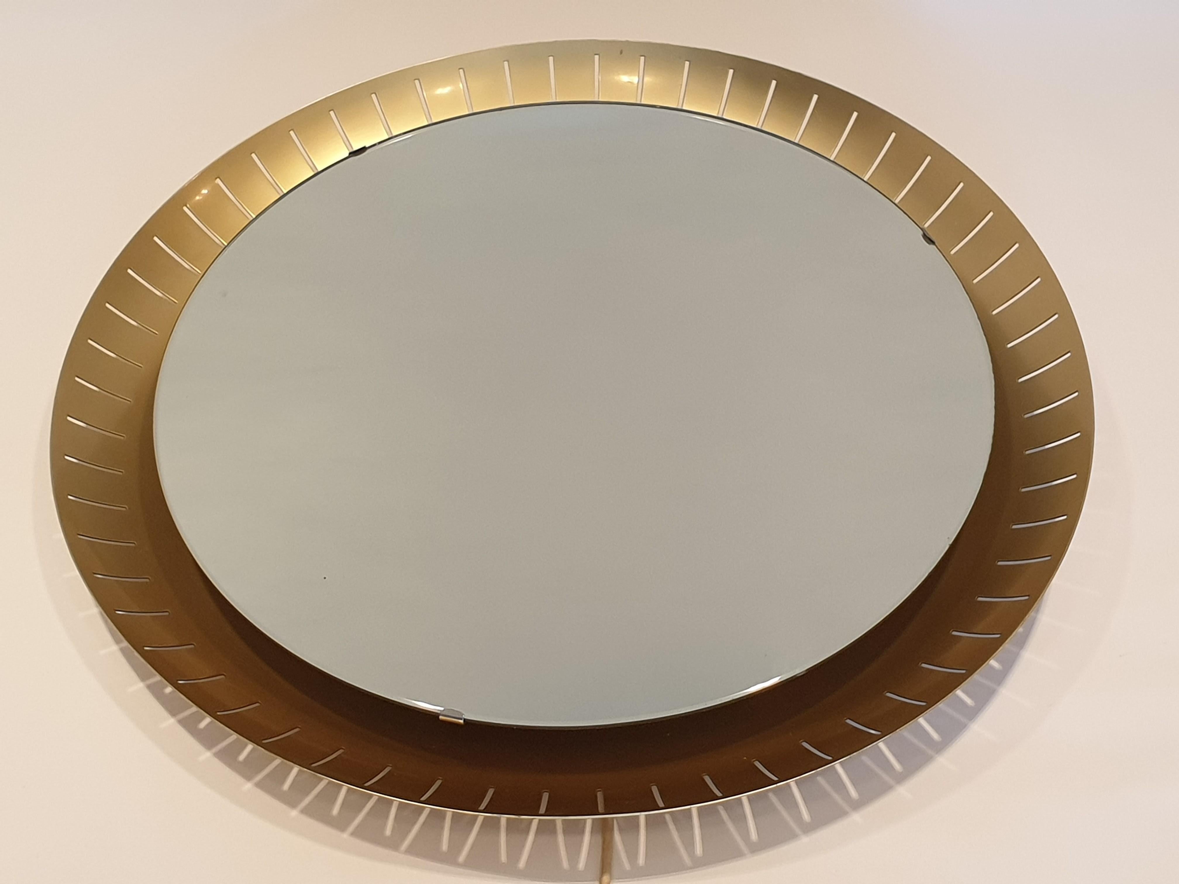 Large illuminated Italian mirror by Stilnovo, with brushed anodised aluminium pierced fretwork frame. The mirror is held in place by metal clips which are easily removable to change the lighting element beneath as can be seen by the photograph. Due