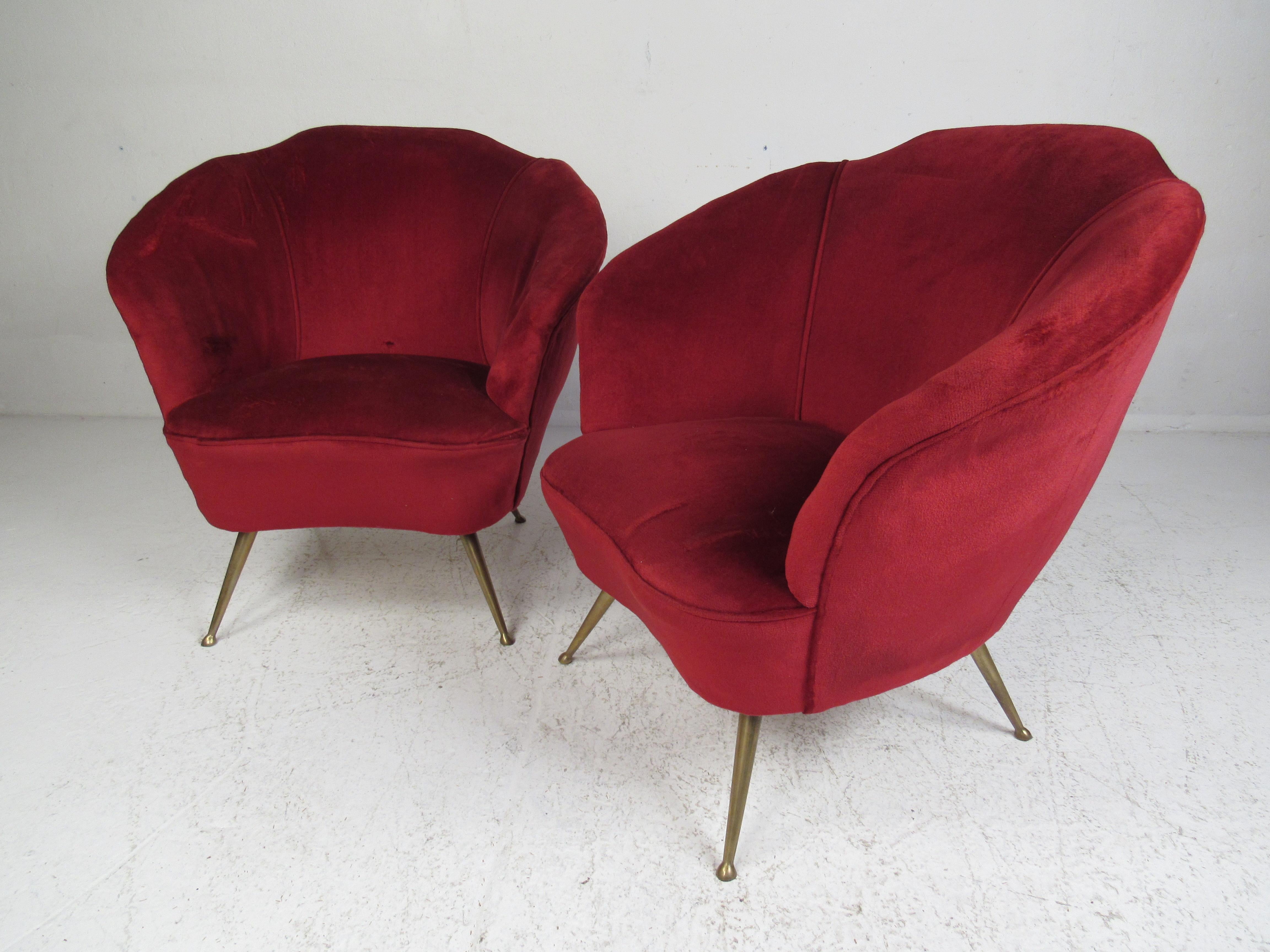 Stunning vintage modern living room set that includes two lounge chairs and a sofa. The red velour upholstery and brass drumstick legs are sure to make an impression in any seating arrangement. A sleek design that features shell barrel backrests and