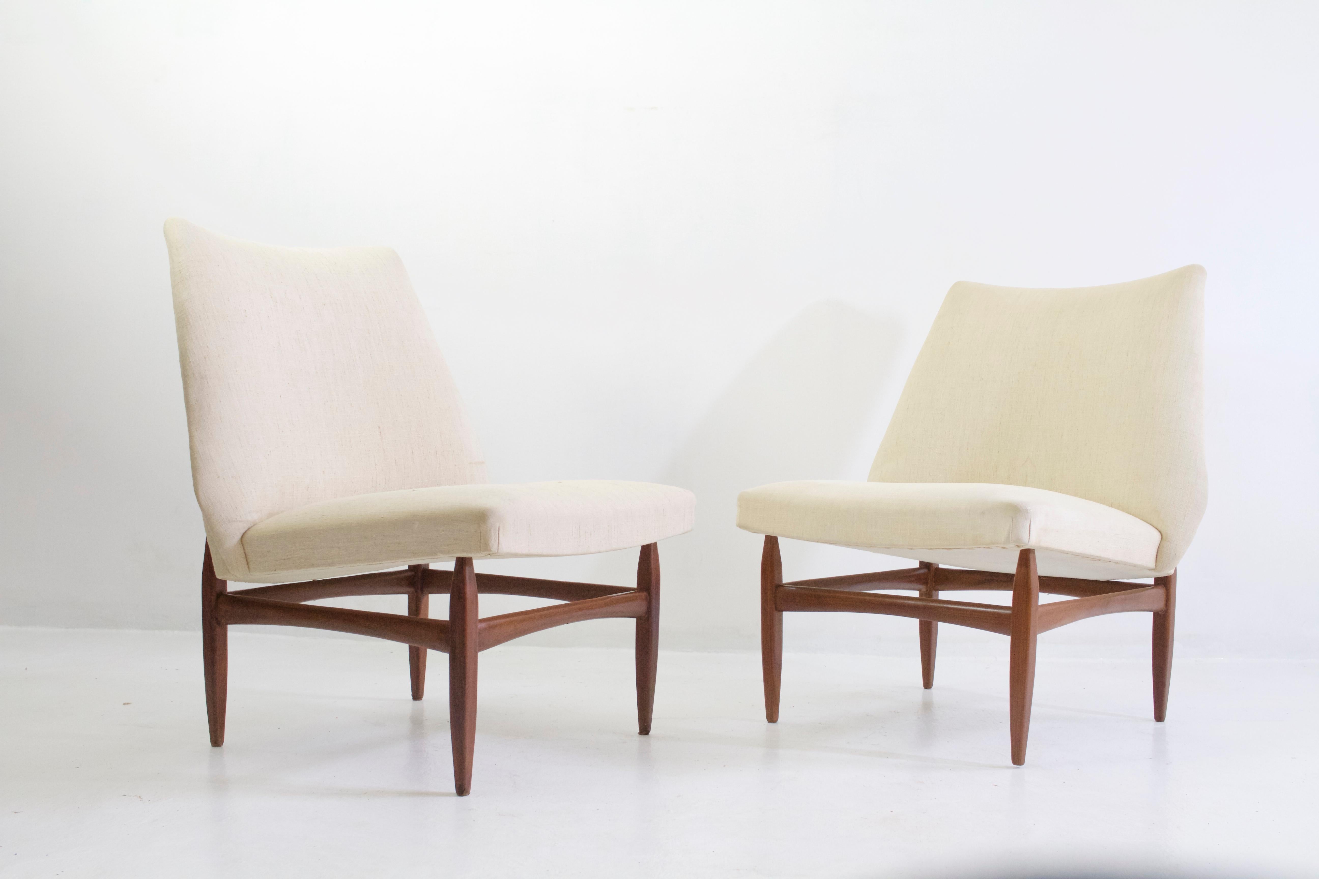 A pair of comfortable and sleek Italian loungechairs, like taken from the TV series Mad Men. They have a sturdy teak base and upholstered seat and back. These chairs are of very good quality but needs to be reupholstered.