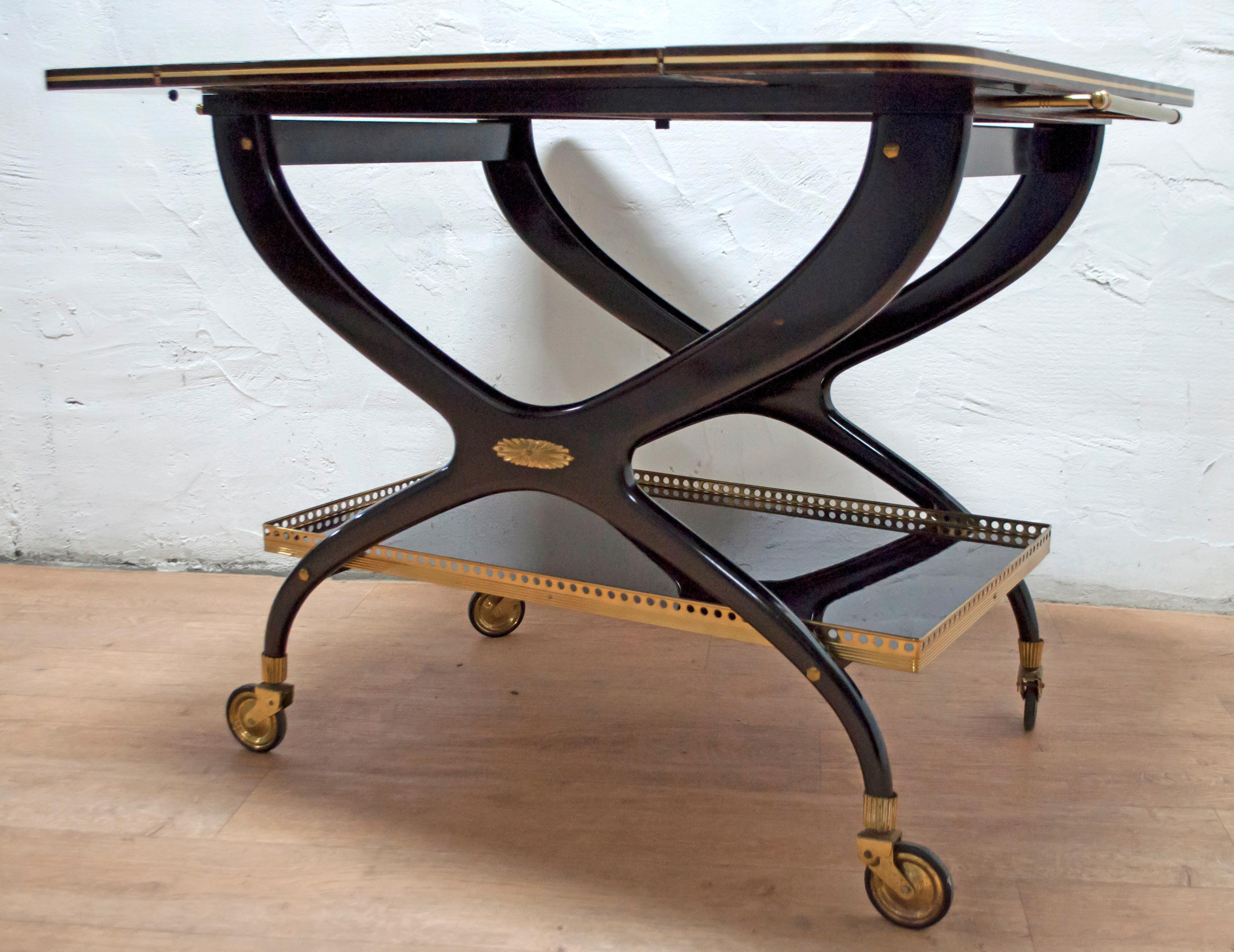 This bar cart is made of mahogany and brass with a folding shelf.

Open top 90 x 85 cm.

