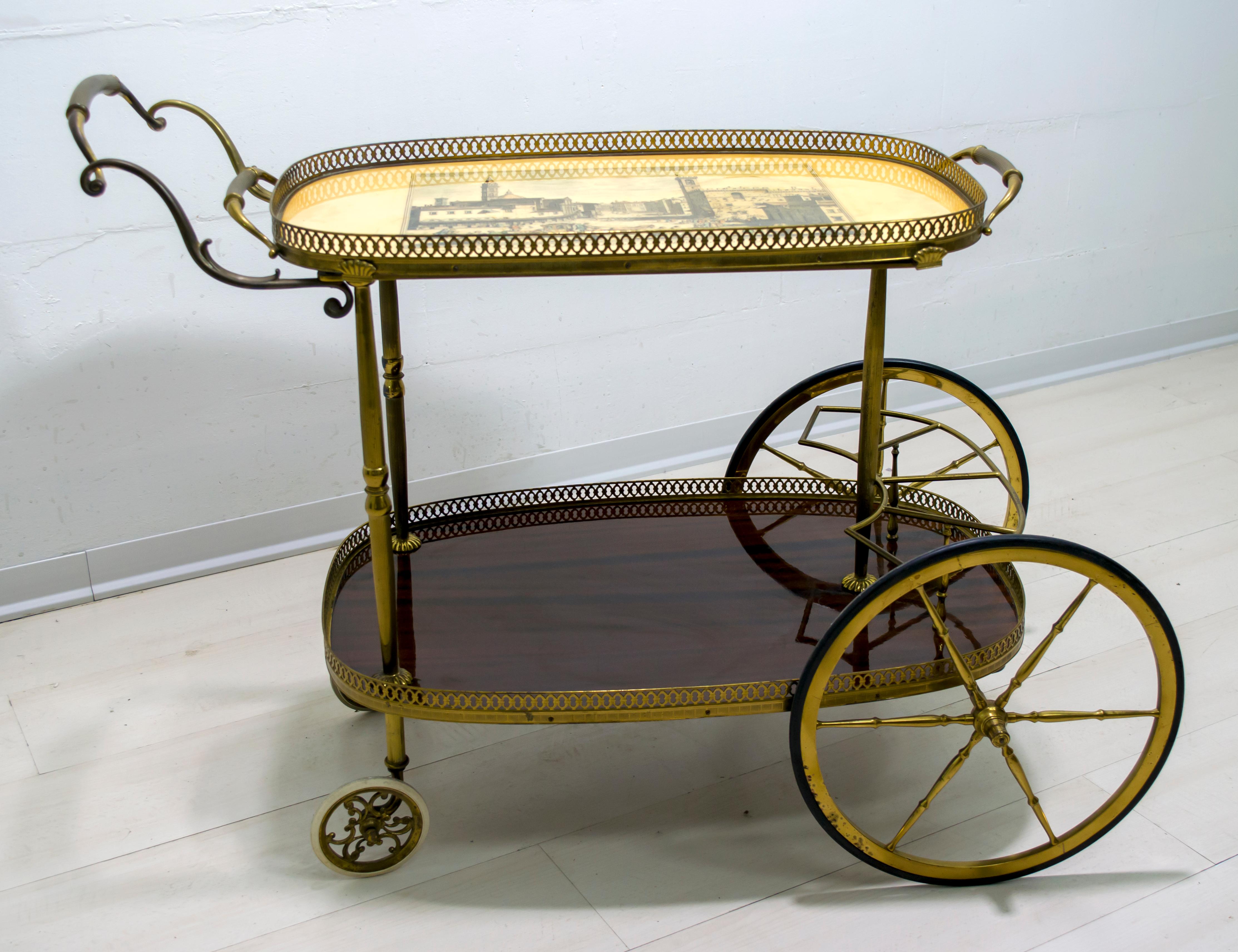 This bar trolley is made of mahogany and brass with a serving tray, an old image of Florence on the tray.

