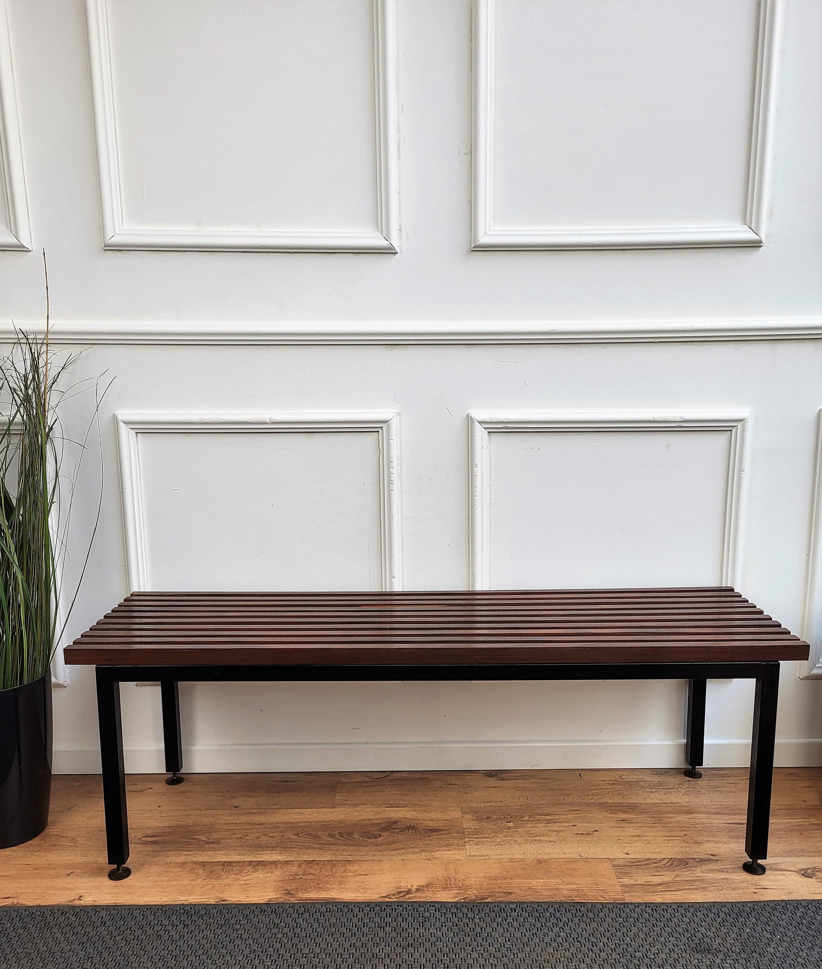 Italian Mid-Century Modern platform slat bench with wood slated top sitting on black metal base and nice brass foot-ends. The perfect piece for a house or building with large expansive windows or a long entrance way for seating or can be used as a