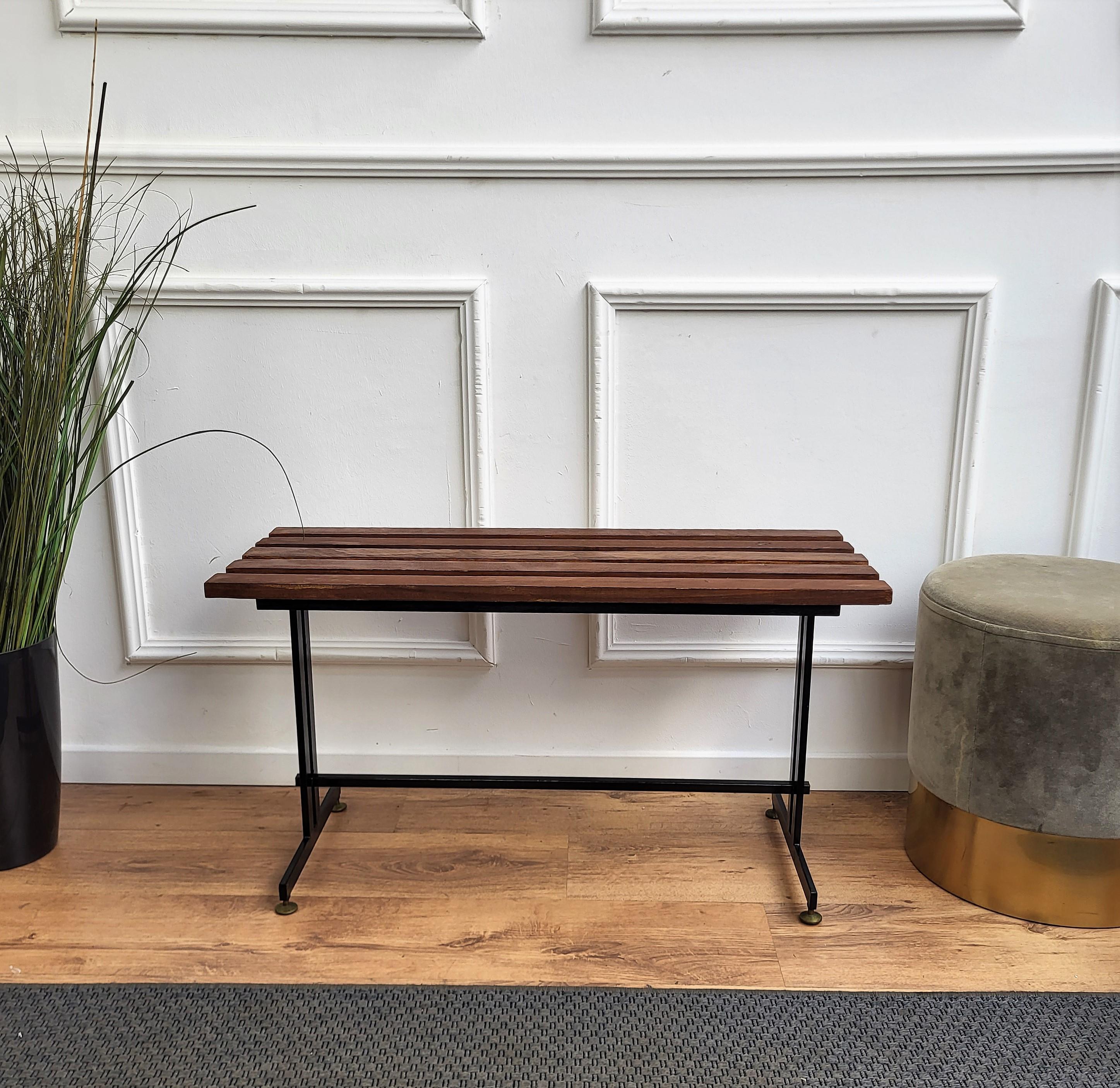 Italian Mid-Century Modern platform slat bench with wood slated top sitting on black metal base and nice brass foot-ends. The perfect piece for a house or building with large expansive windows or a long entrance way for seating or can be used as a